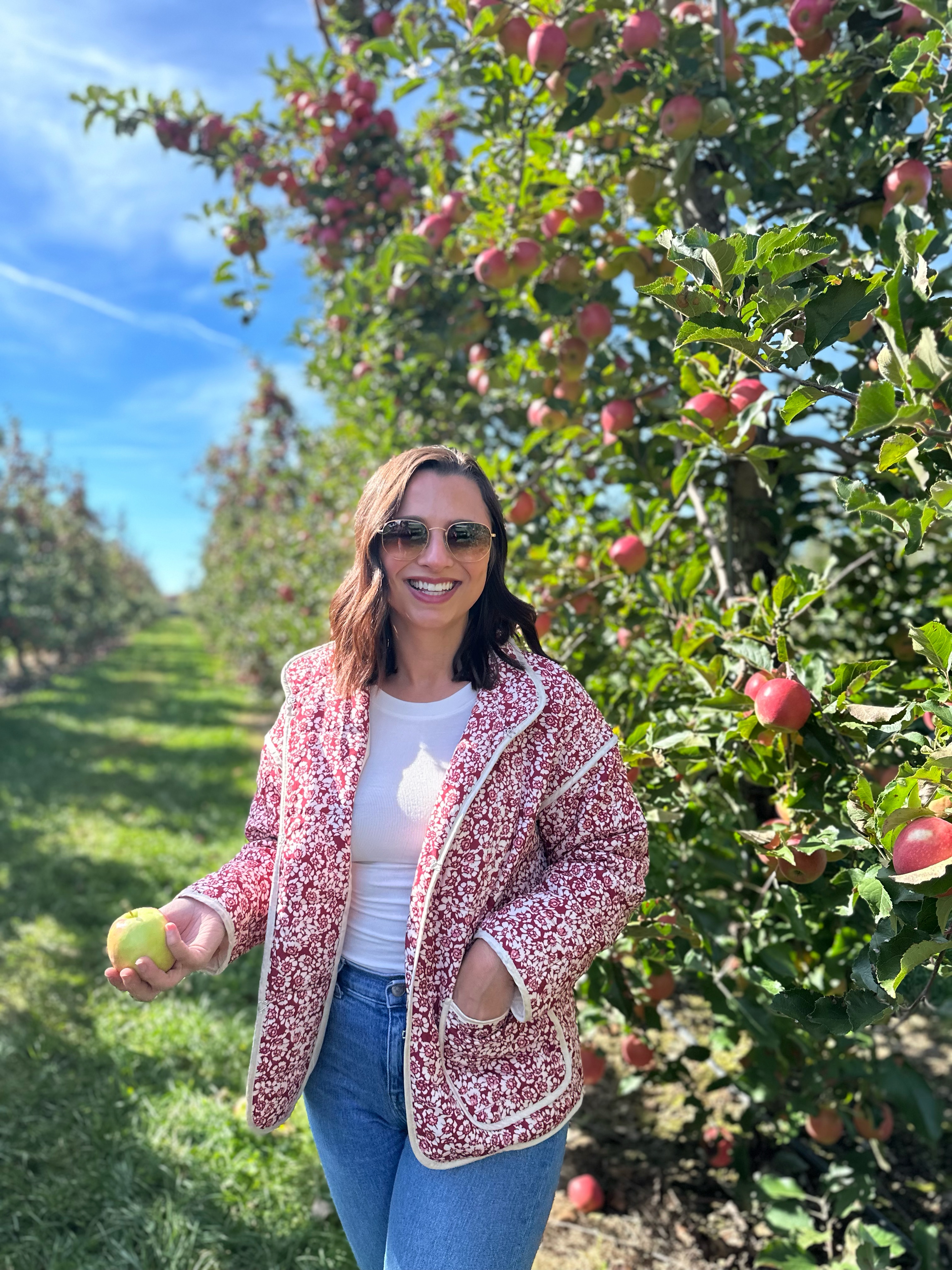 Kayla Scheidel smiling outdoors among fall leaves