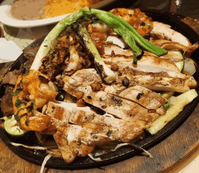A plate of food with chicken, shrimp, and vegetables.