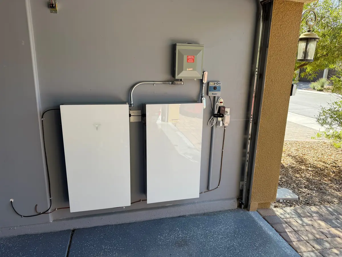 Two Tesla Powerwalls installed under a covered wall of a Nevada home