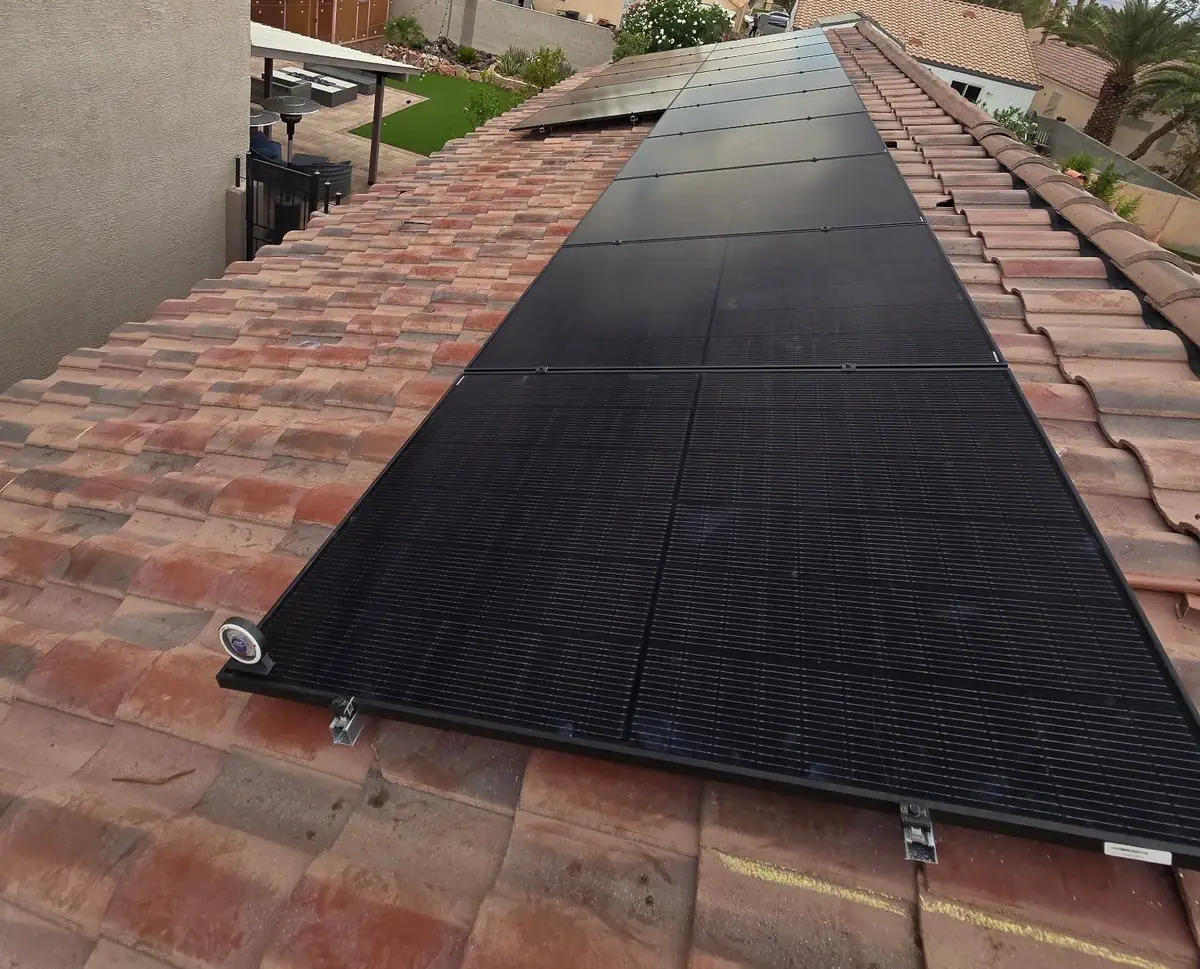 Close-up of a row of all-black solar panels mounted on a clay tile roof in Arizona