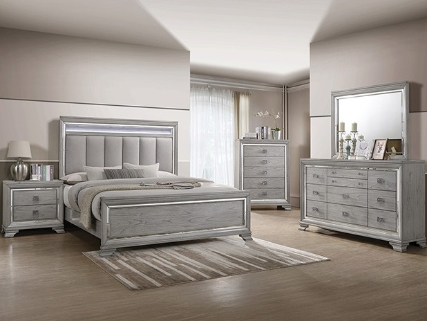Grey bedroom set with mirrored trim and an upholstered headboard