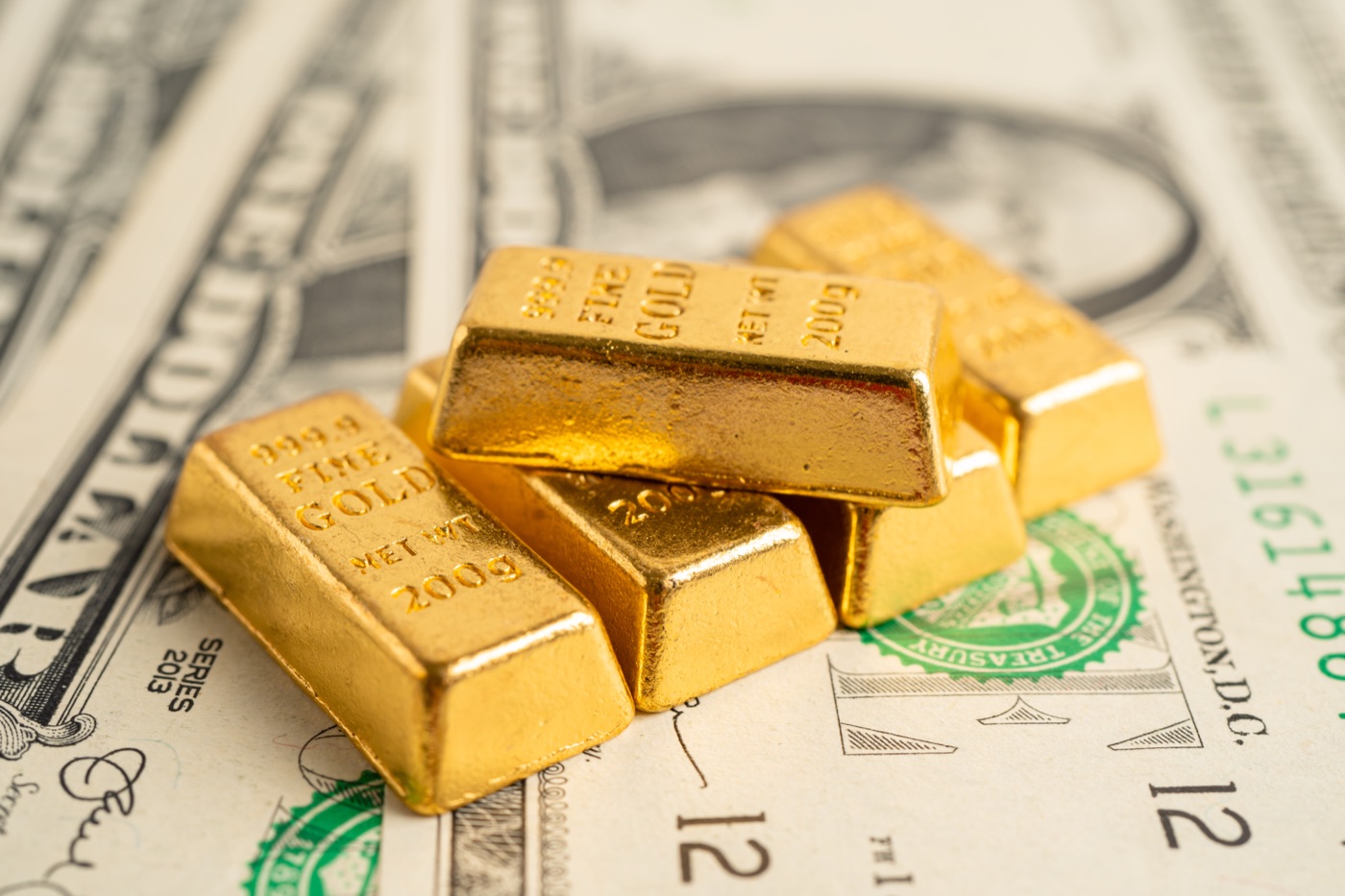 Gold coins and rings beside a strand of pearls
