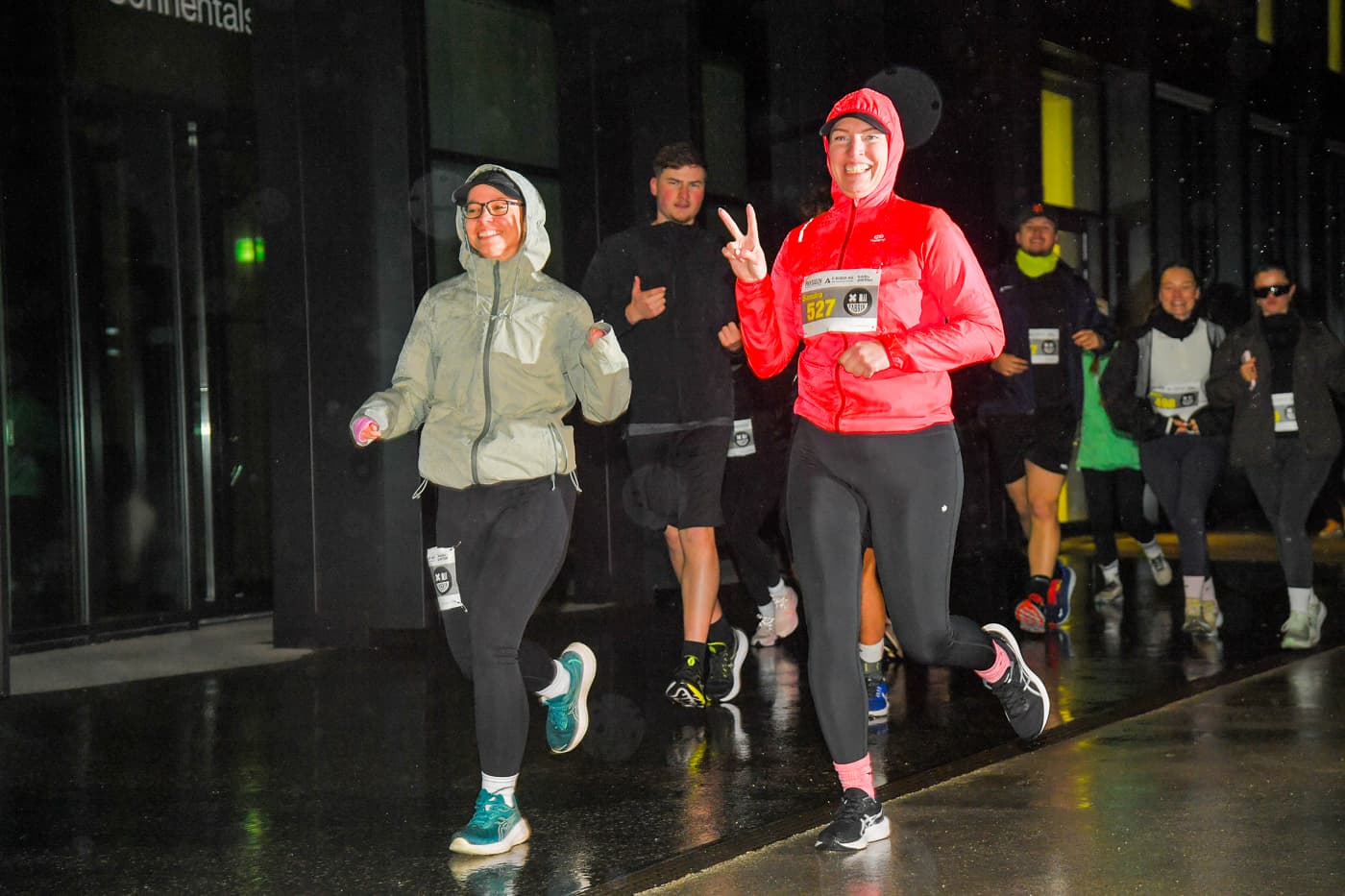 Peace Zeichen im Regen, Läuferinnen beim nächtlichen NightRun in Dübendorf