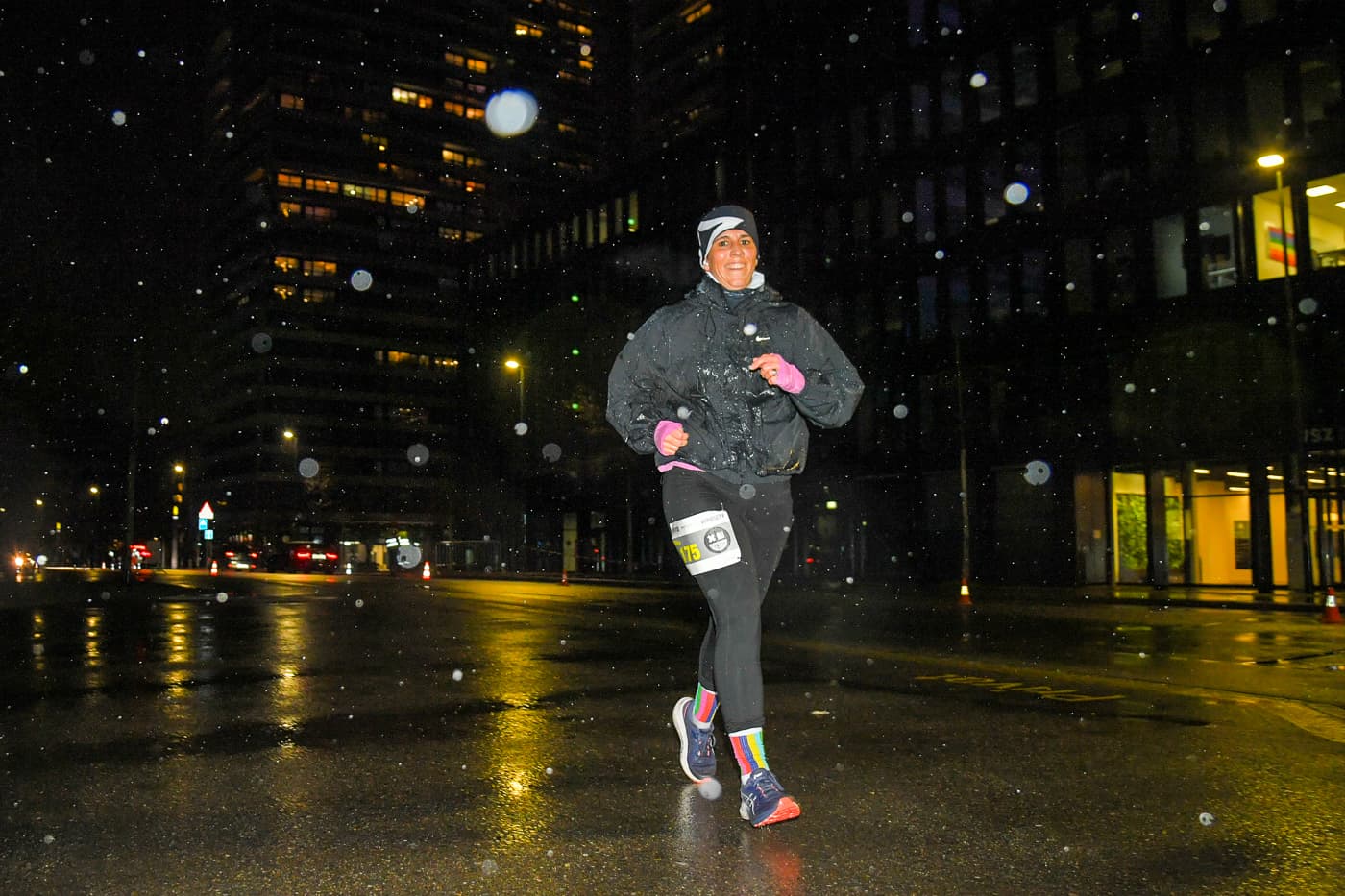 5 km Nachtlauf beim NightRun in Dübendorf, Läuferin im Regen auf der Strecke