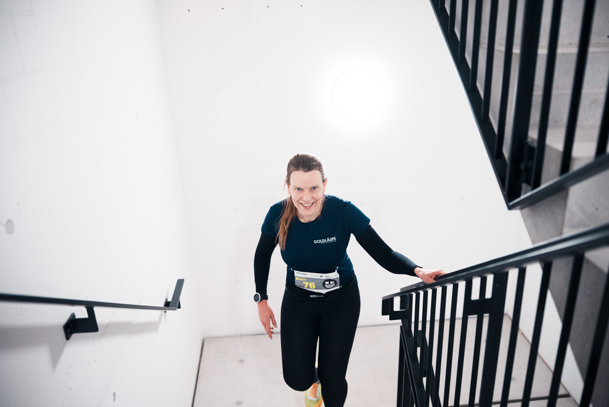 Lächelnde Läuferin auf der Treppe beim Tower Run des NightRun Zürich in Dübendorf