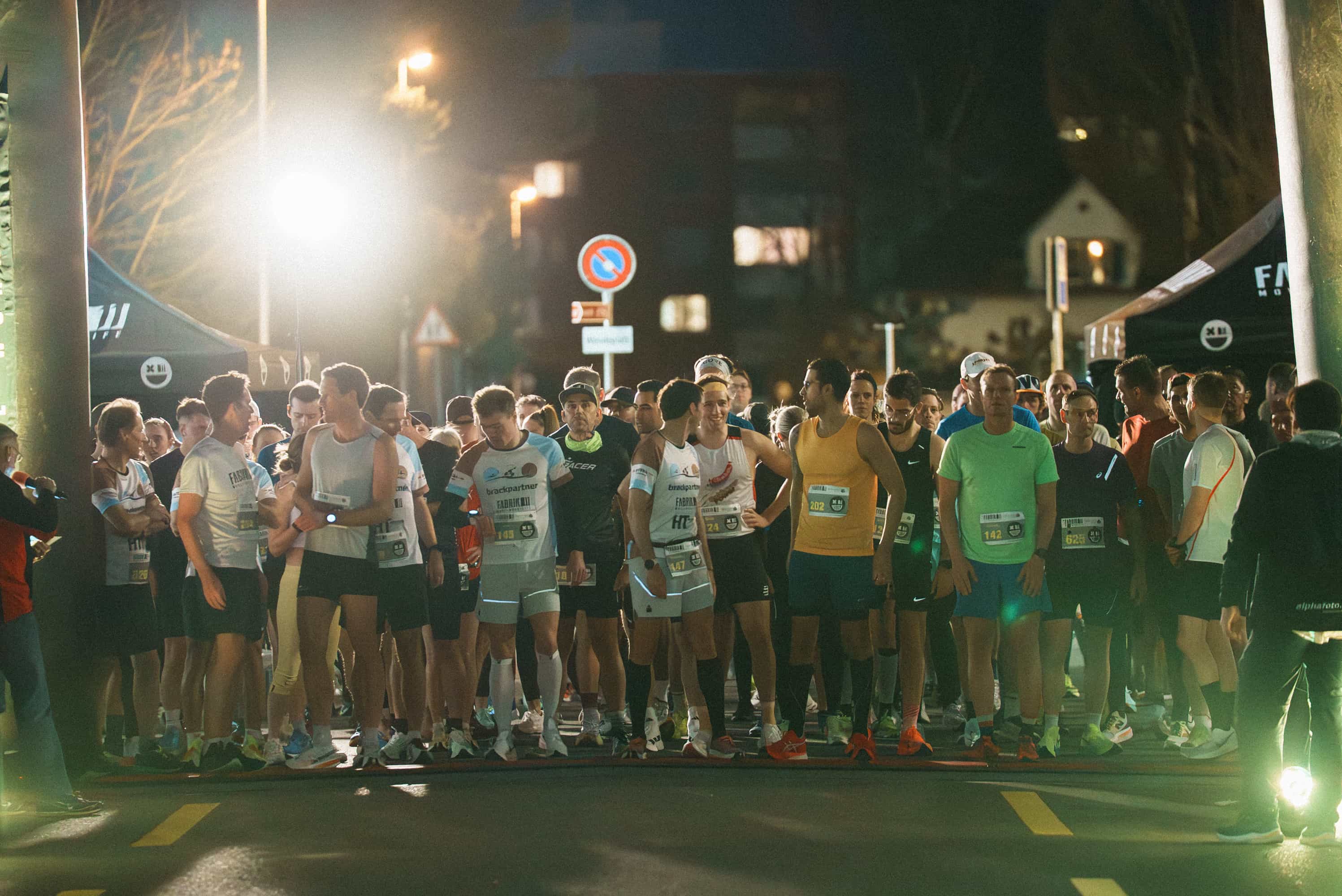 Impression vom Start des NightRun Zürich, Läuferfeld in Dübendorf am Abend