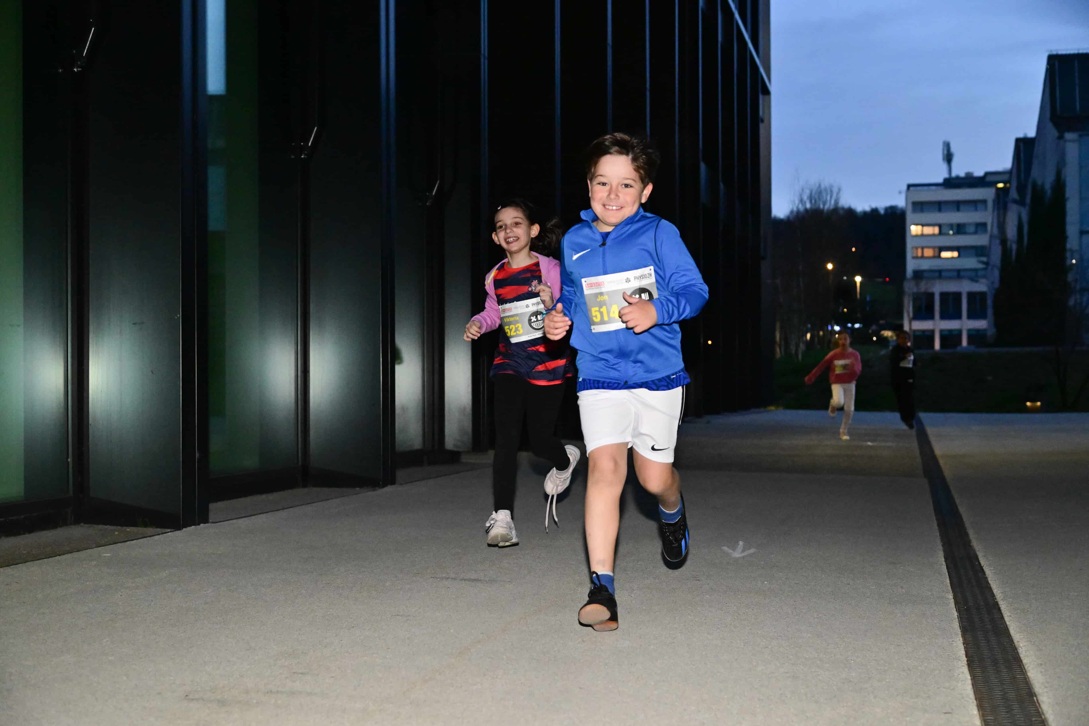 Lachende Kinder beim Kids Run des NightRun in Dübendorf nahe Zürich