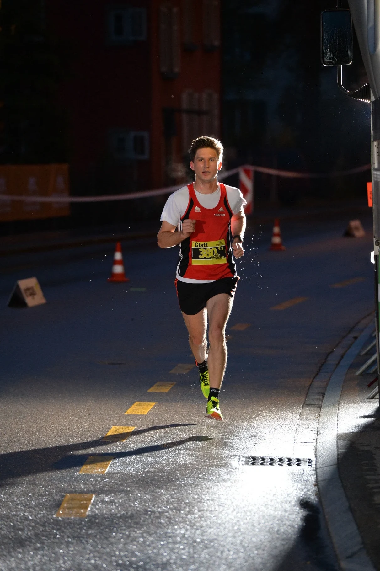 NightRun Wallisellen 2016: Läufer im roten Trikot auf nasser Strasse