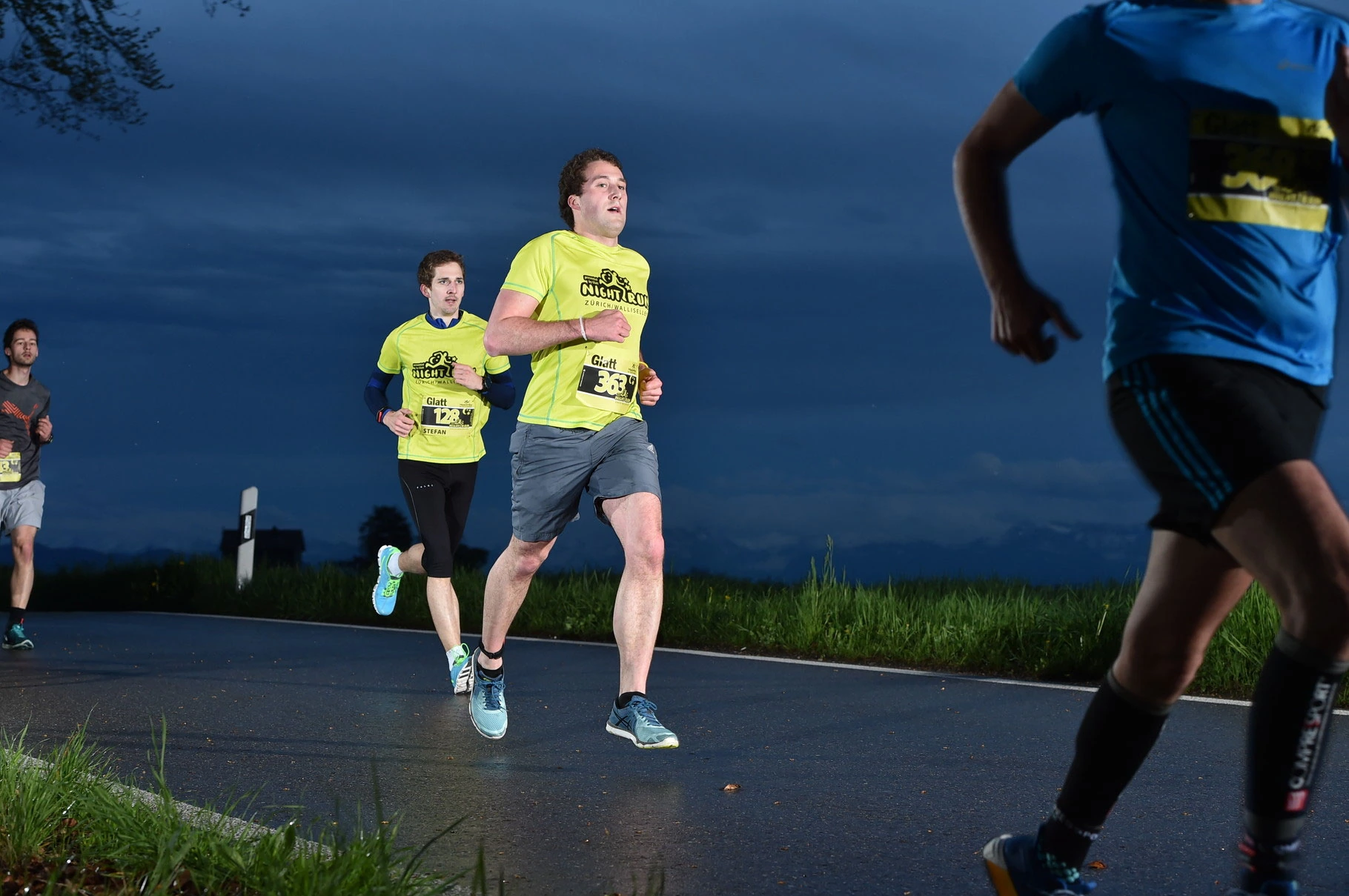 NightRun Wallisellen 2016: Läufer in gelben Shirts in der blauen Stunde