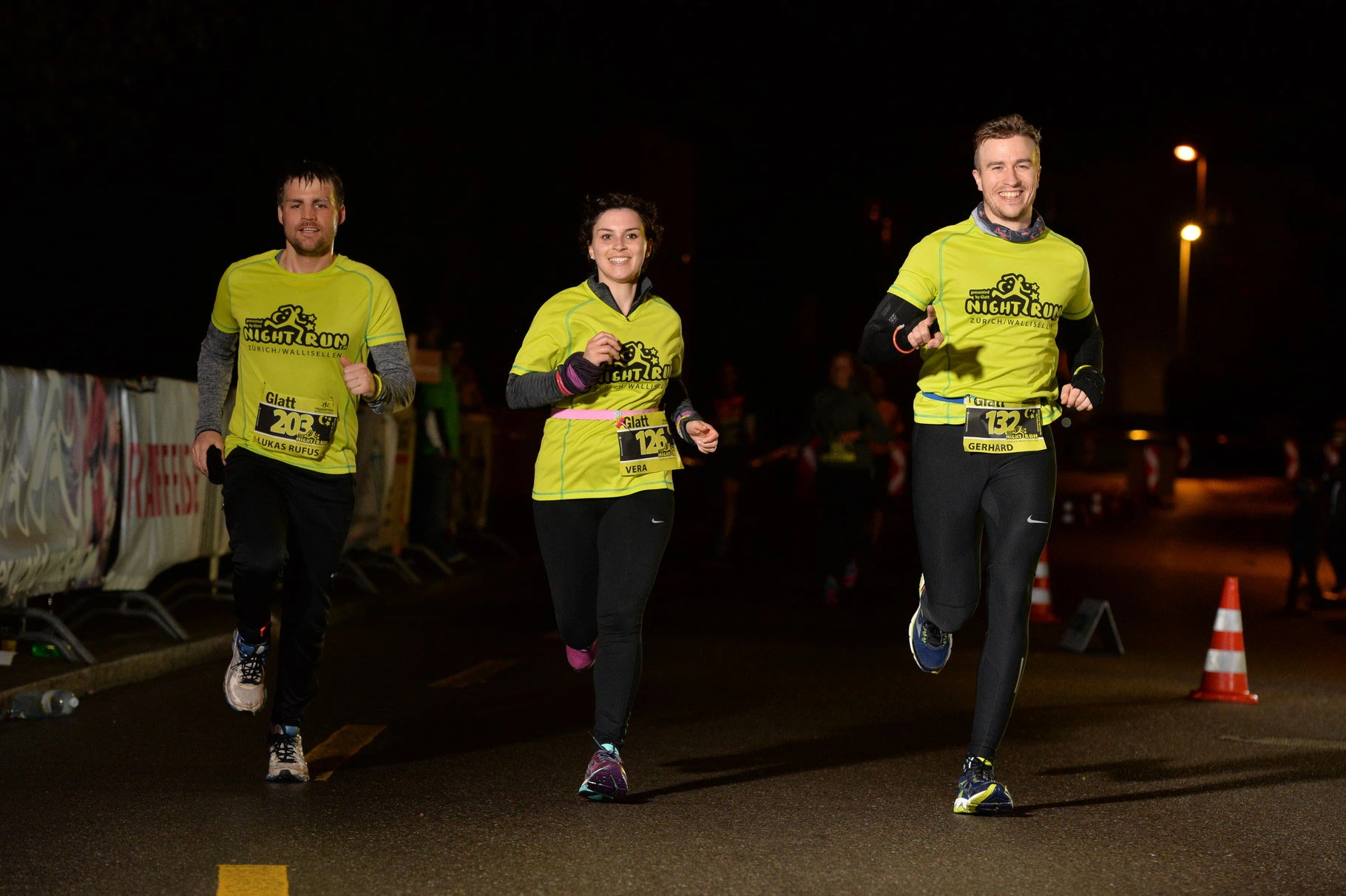 NightRun Wallisellen 2016: Drei Läufer in gelben Shirts auf der Strecke bei Nacht