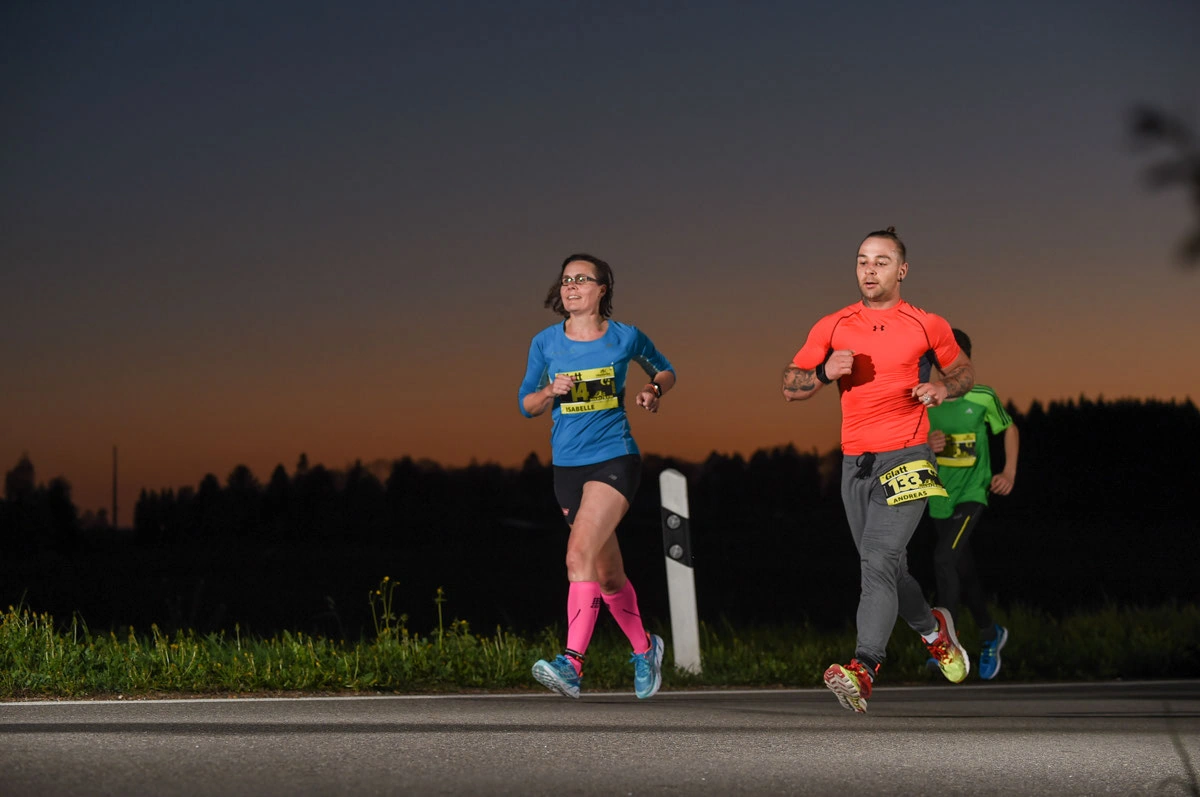 NightRun 2018 Wallisellen: Zwei Läufer im Abendlicht auf der Strasse