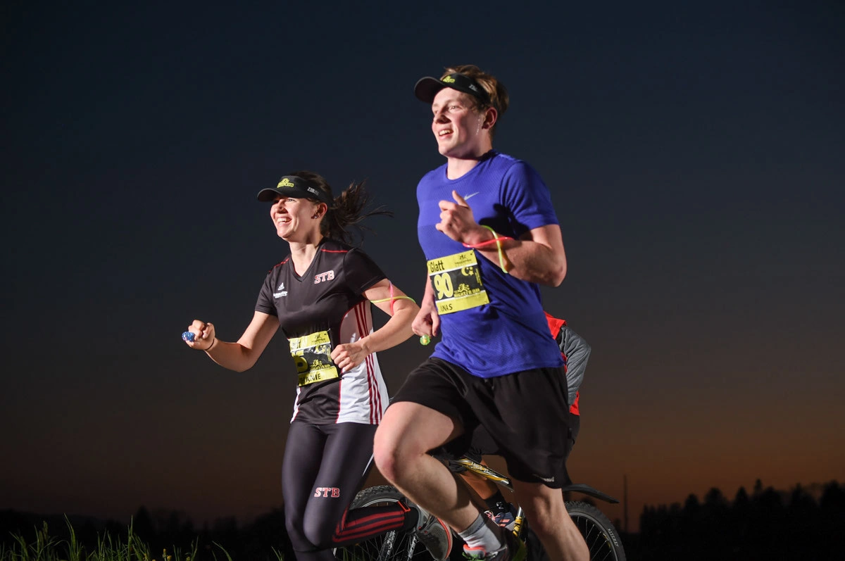 NightRun 2018 Wallisellen: Zwei Läufer in der Dämmerung, daneben ein Velo
