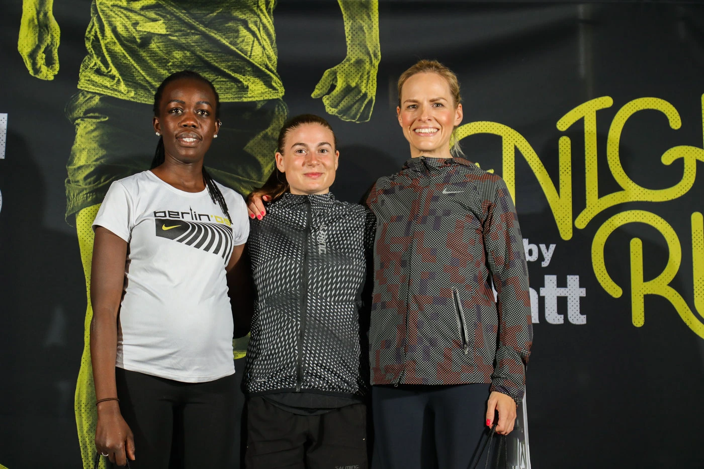 Glatt NightRun 2019: Drei Läuferinnen posieren vor der Glatt NightRun Wand