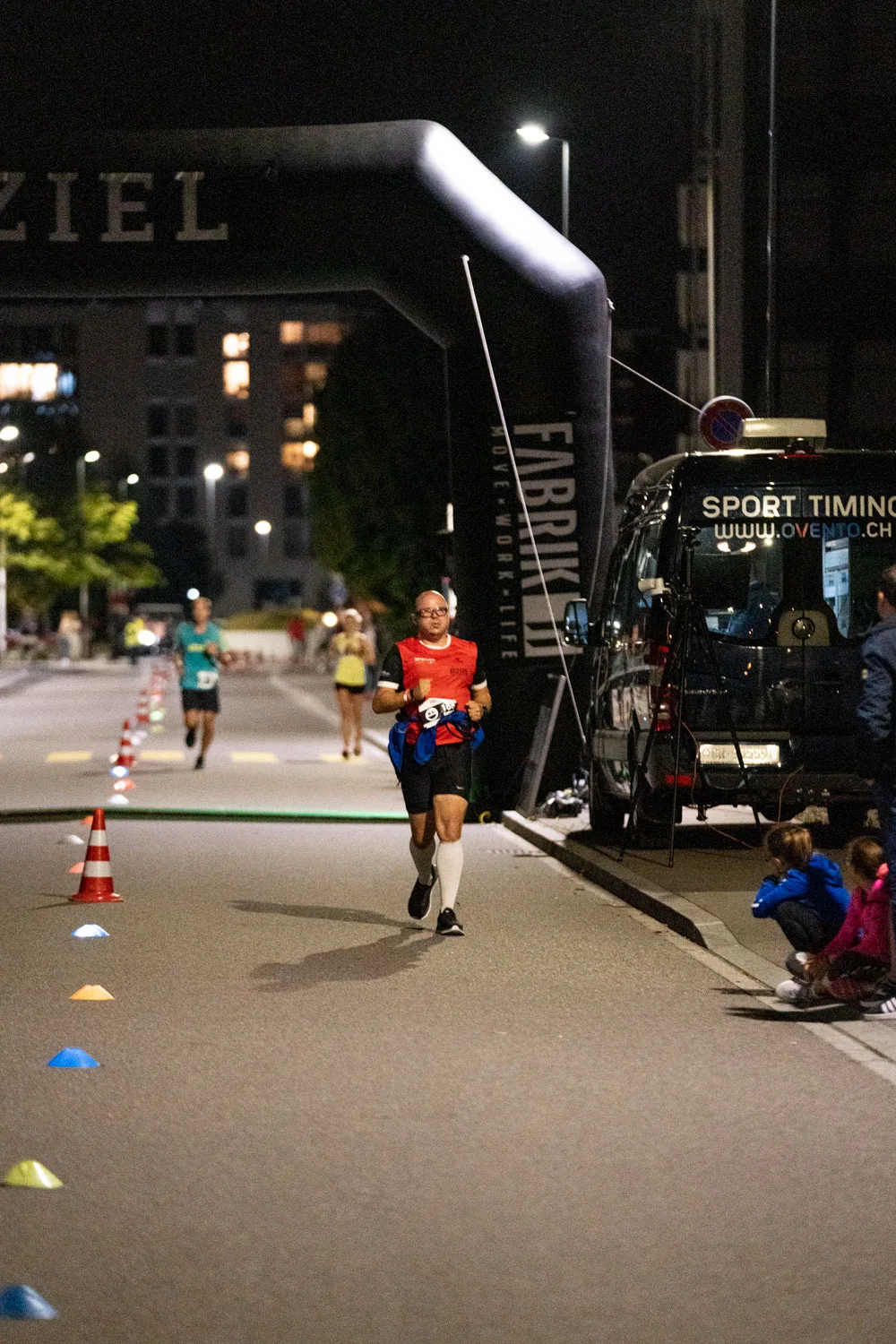 NightRun Dübendorf 2021: Läufer auf der Strecke unter dem Zielbogen