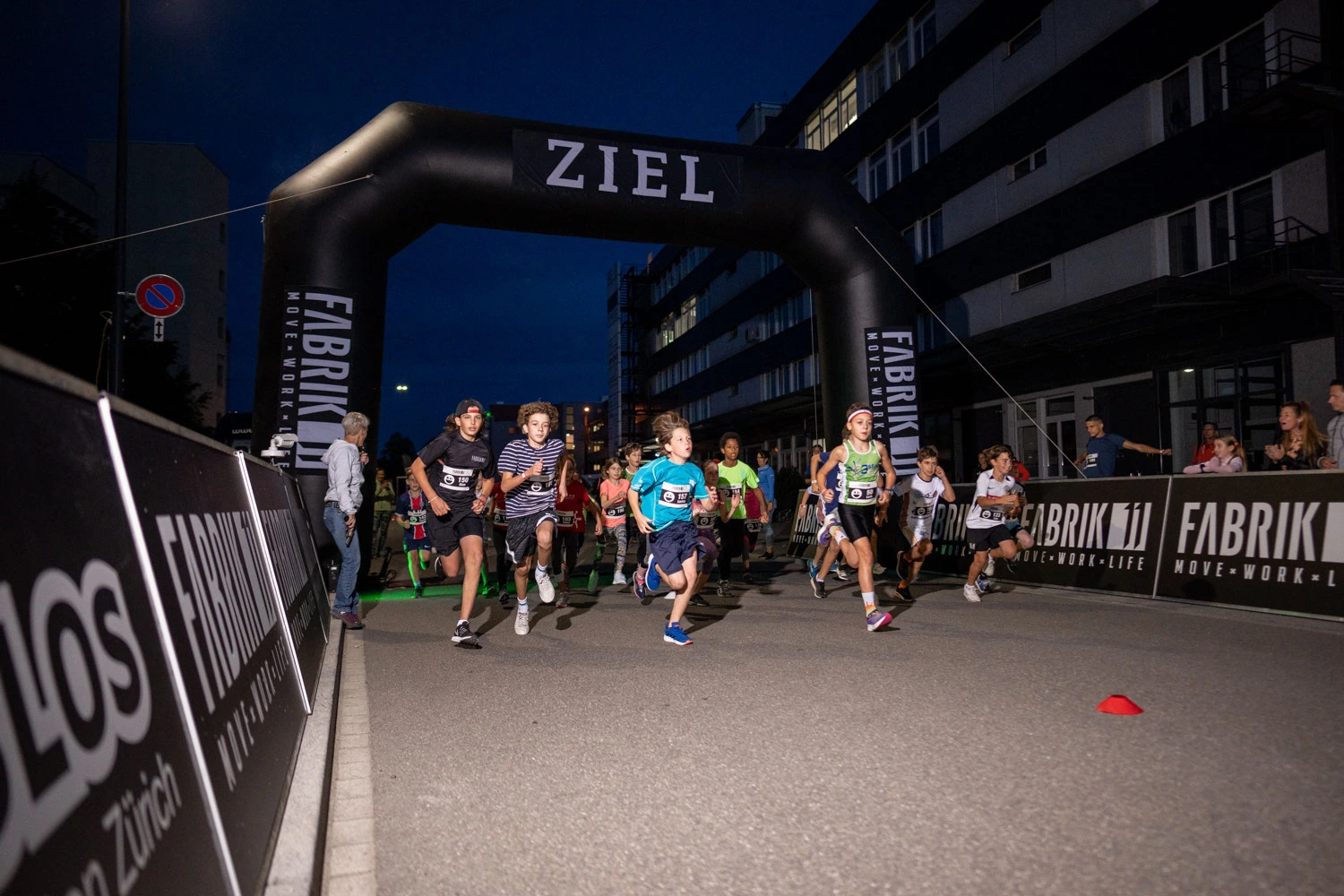 NightRun Dübendorf 2021: Läuferinnen und Läufer erreichen am Abend den Zielbogen