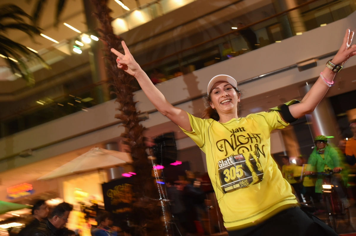 Glatt NightRun 2017: Läuferin im gelben Shirt jubelt mit erhobenen Armen