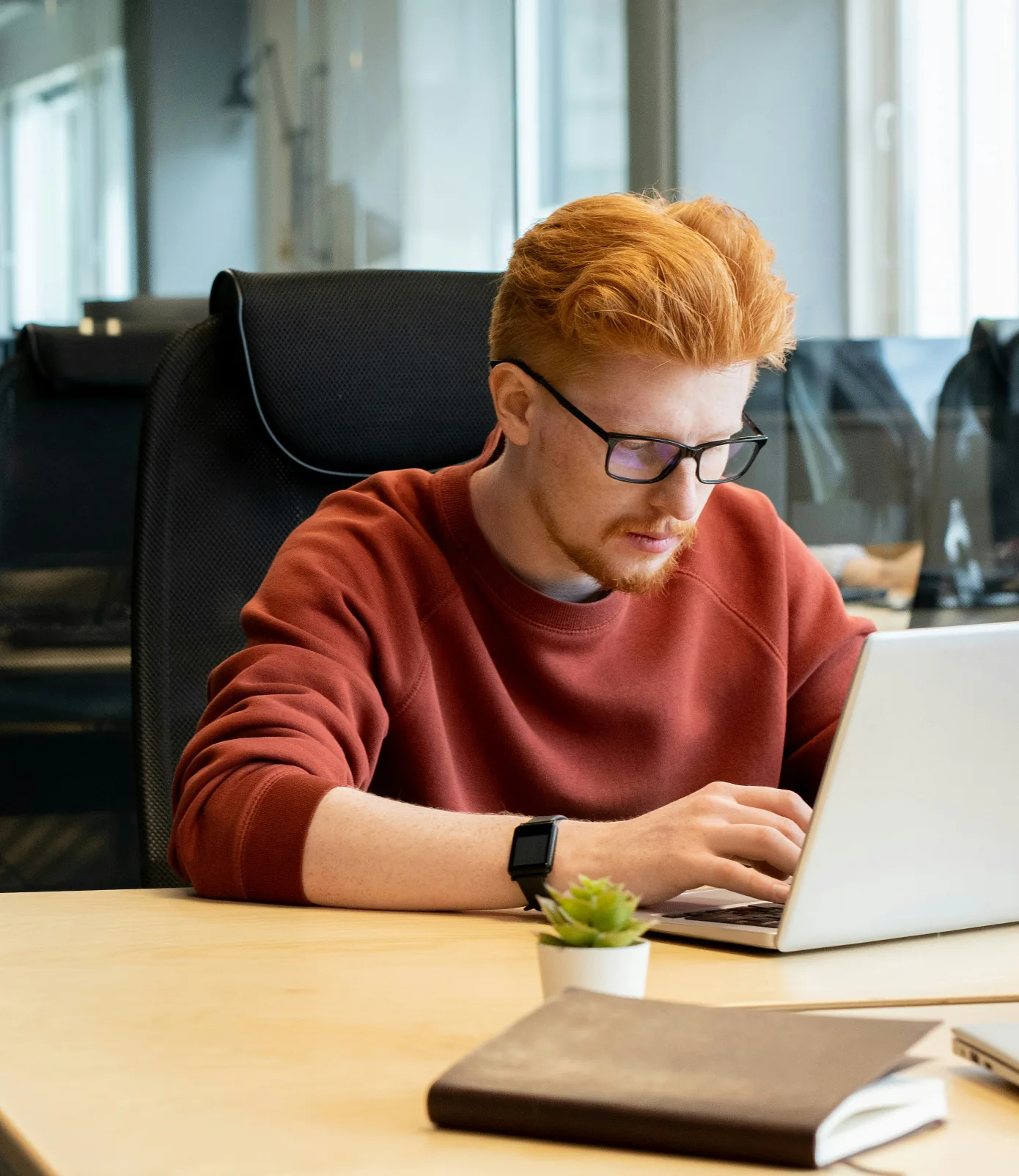 Consultant Soluxan travaillant sur un ordinateur portable à son bureau