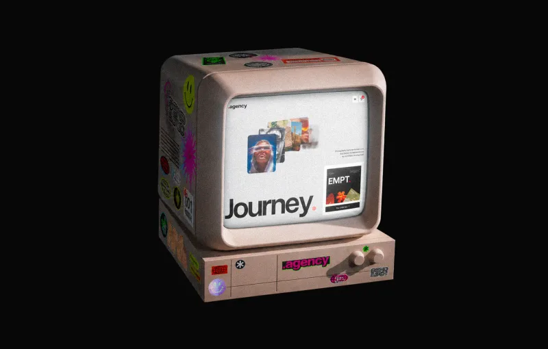 A 3D render of a beige retro computer covered in stickers, its screen showing the Journey website template, on a black background.