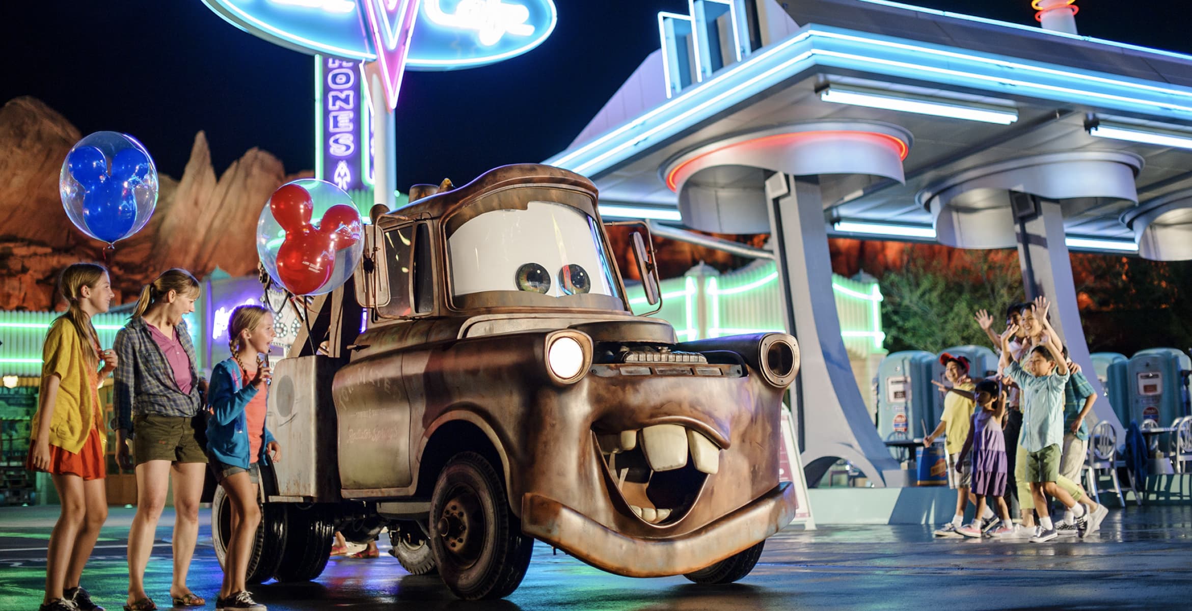 Families meeting Mater in Cars Land at night