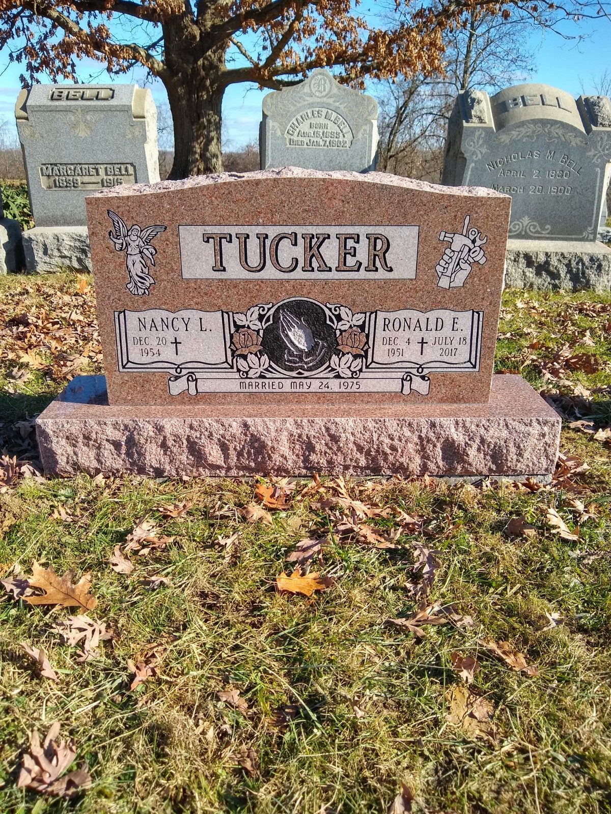 Red granite upright monument with a carved portrait panel