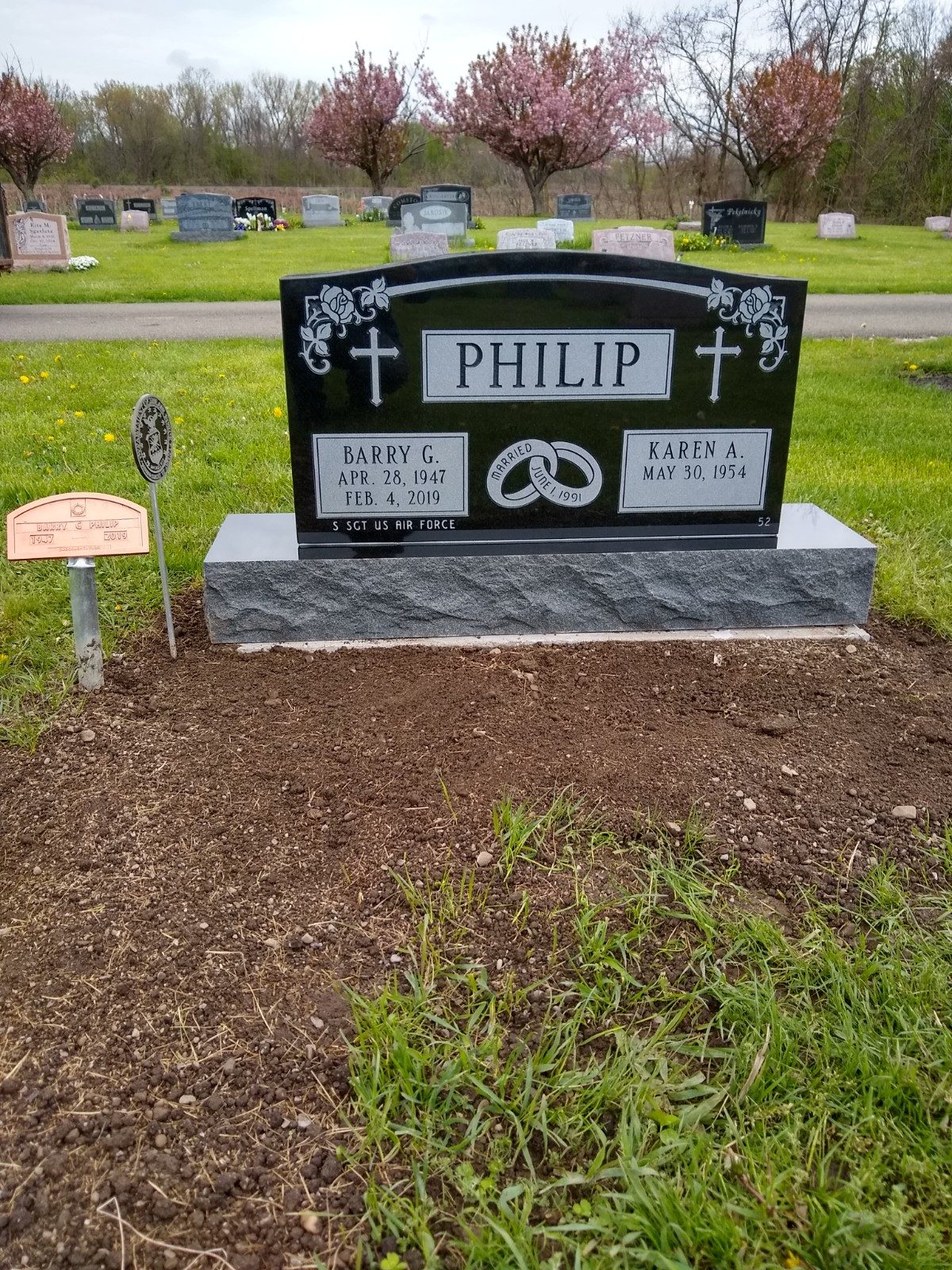 Black granite upright monument with etched emblems