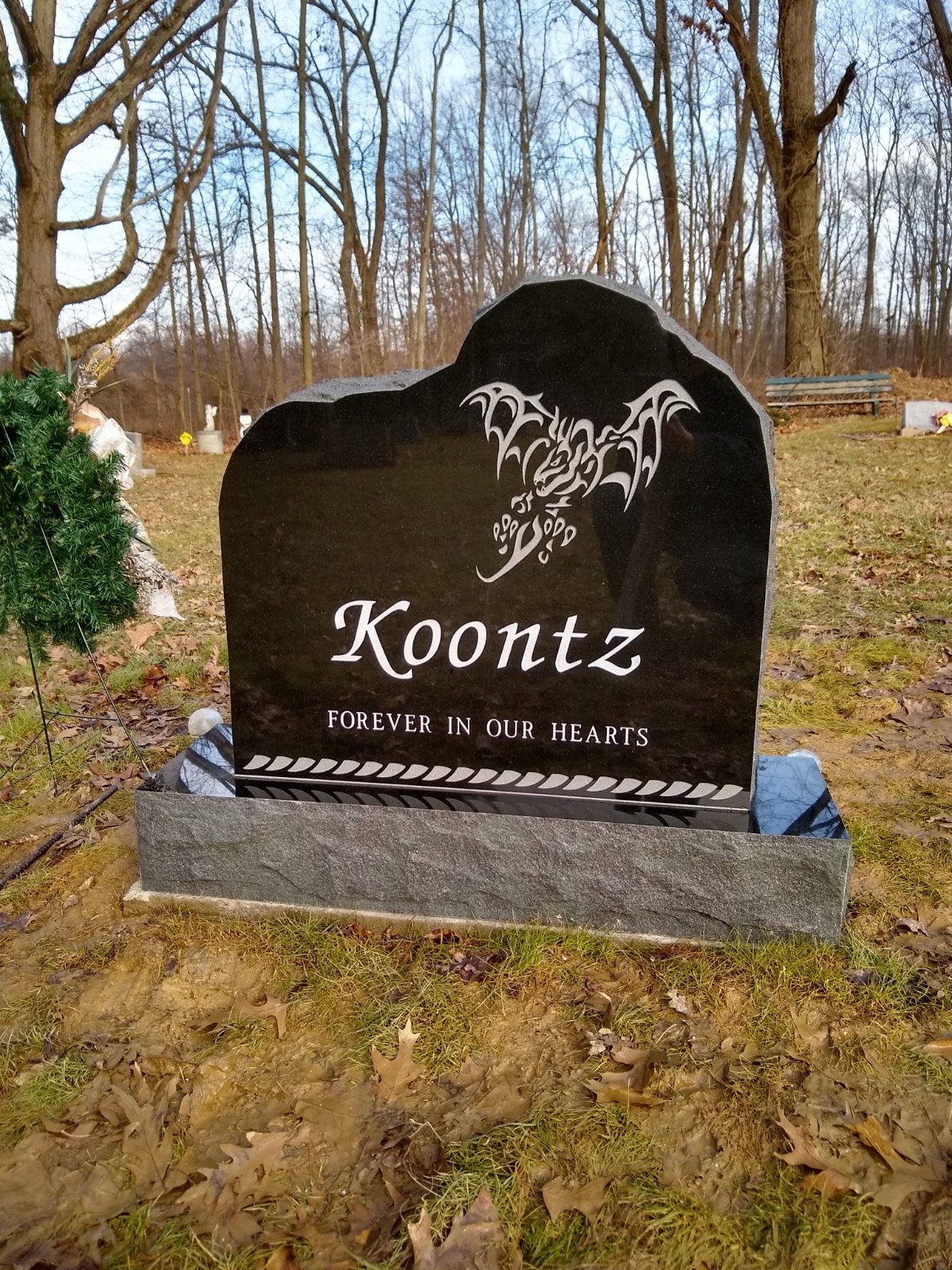 Custom-shape black granite monument with a carved design