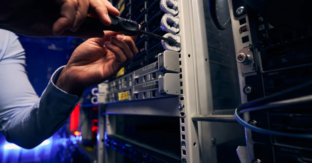 A technician working on equipment in a server rack