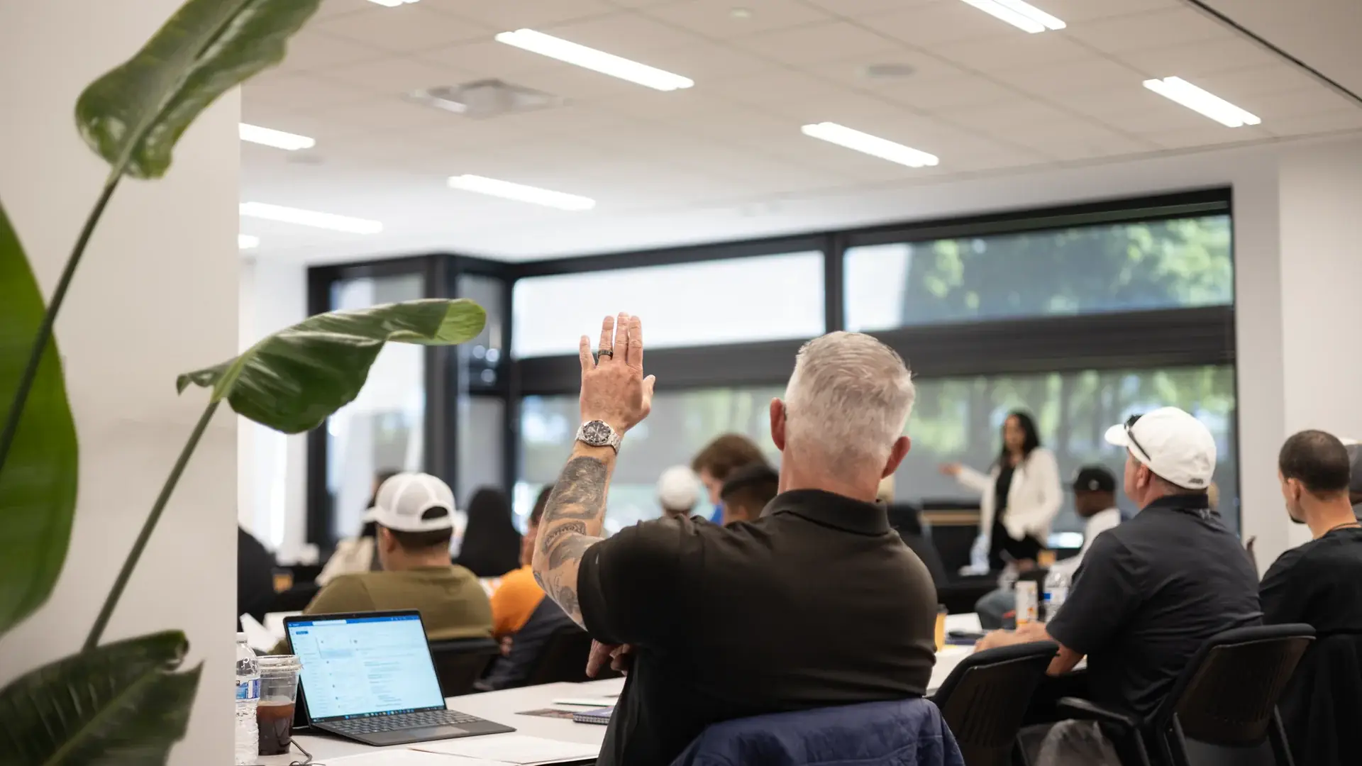 A student raising a hand to ask a question in class