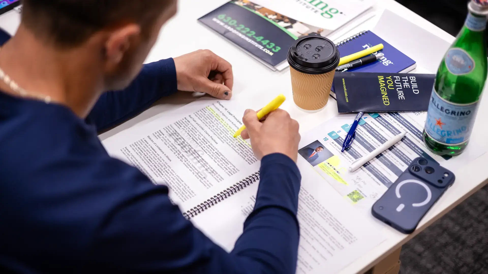 A student highlighting the course workbook in class
