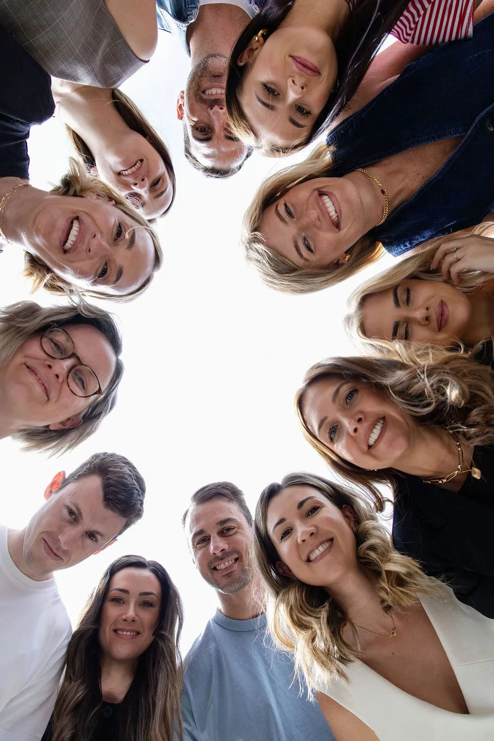 The Sneaky Digital team in a huddle, looking down at the camera