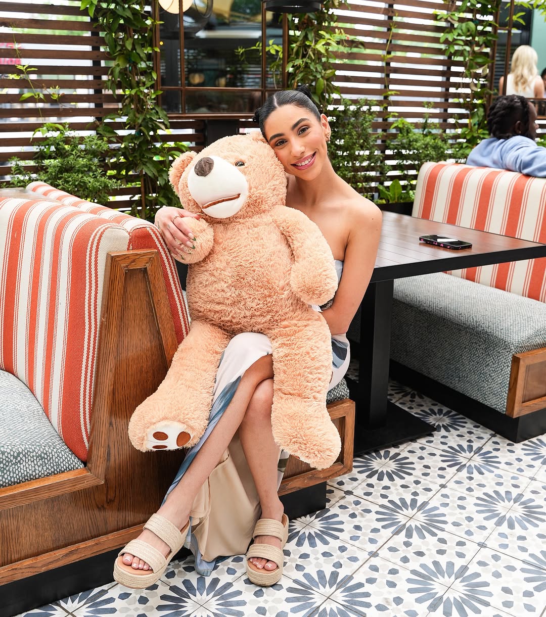 A guest with the bear in a striped patio booth
