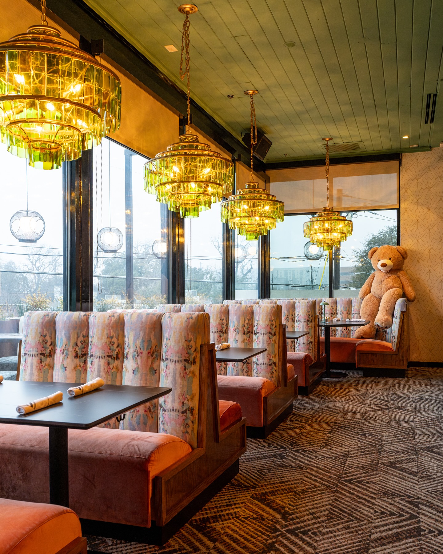 The upstairs dining room at The Charlotte, with glass chandeliers and patterned booths