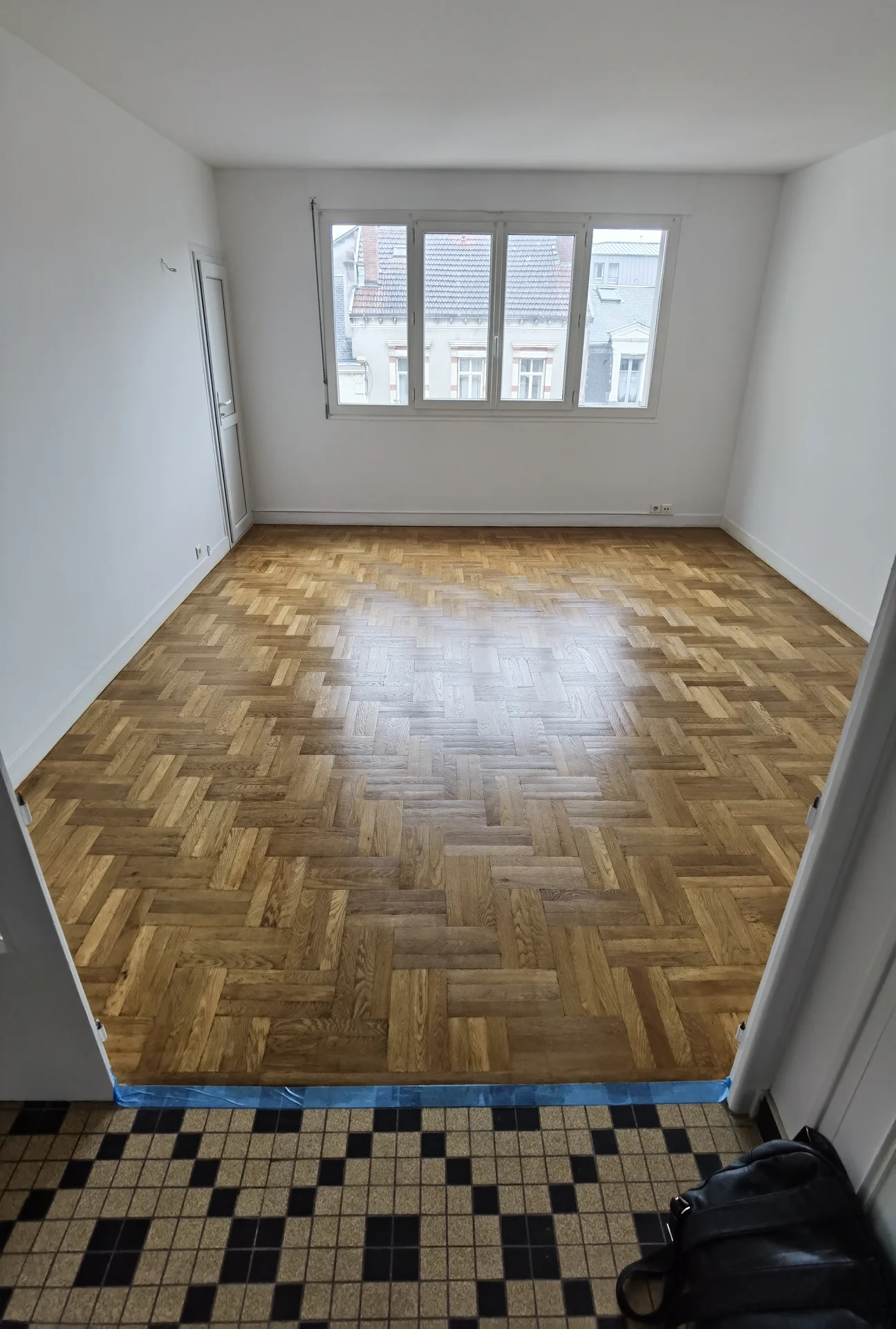 Parquet en chevrons avec finition brillante dans une pièce rénovée