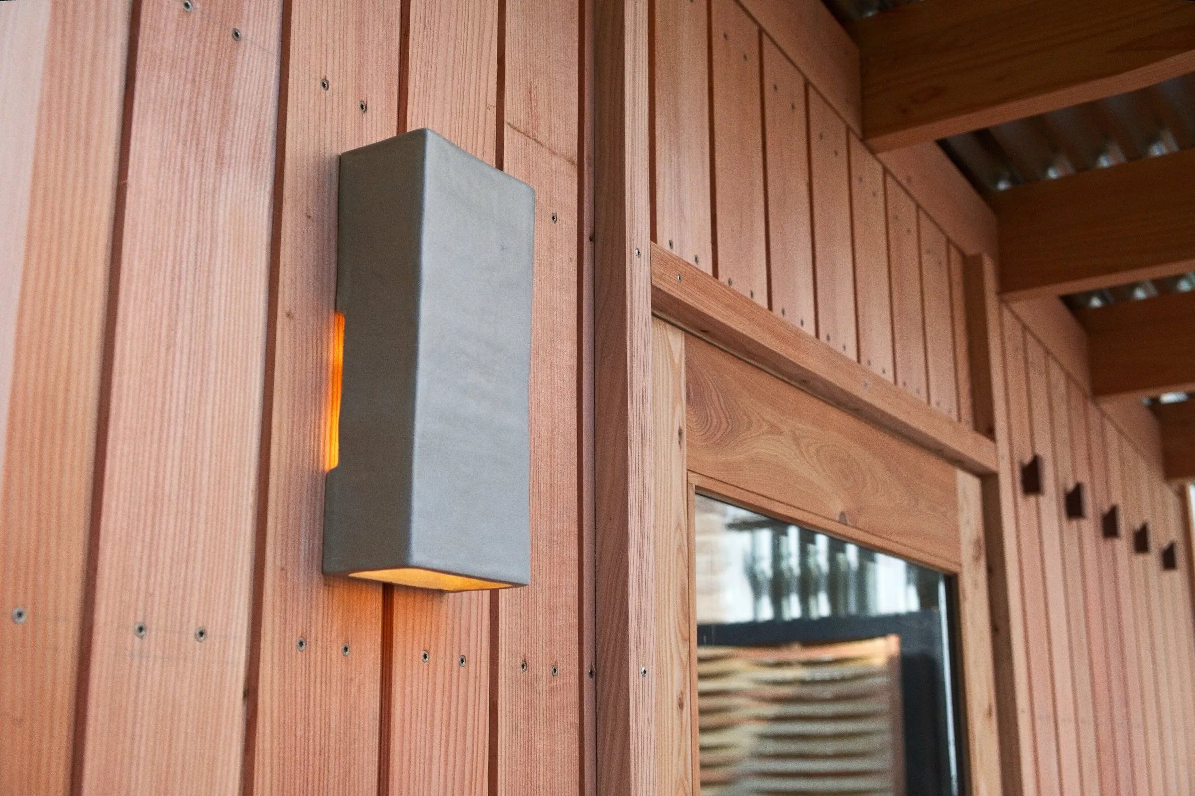 Vertical timber cladding and wall light on the St Anne's community sauna