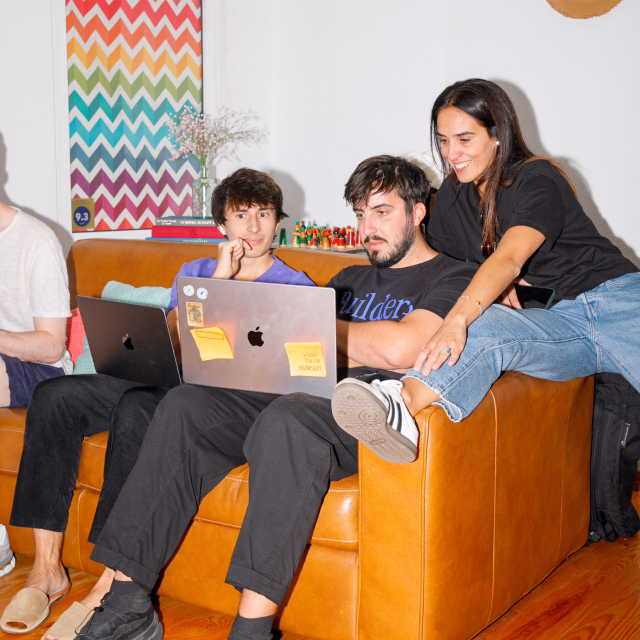 Nory team members collaborating around a laptop in a relaxed lounge setting