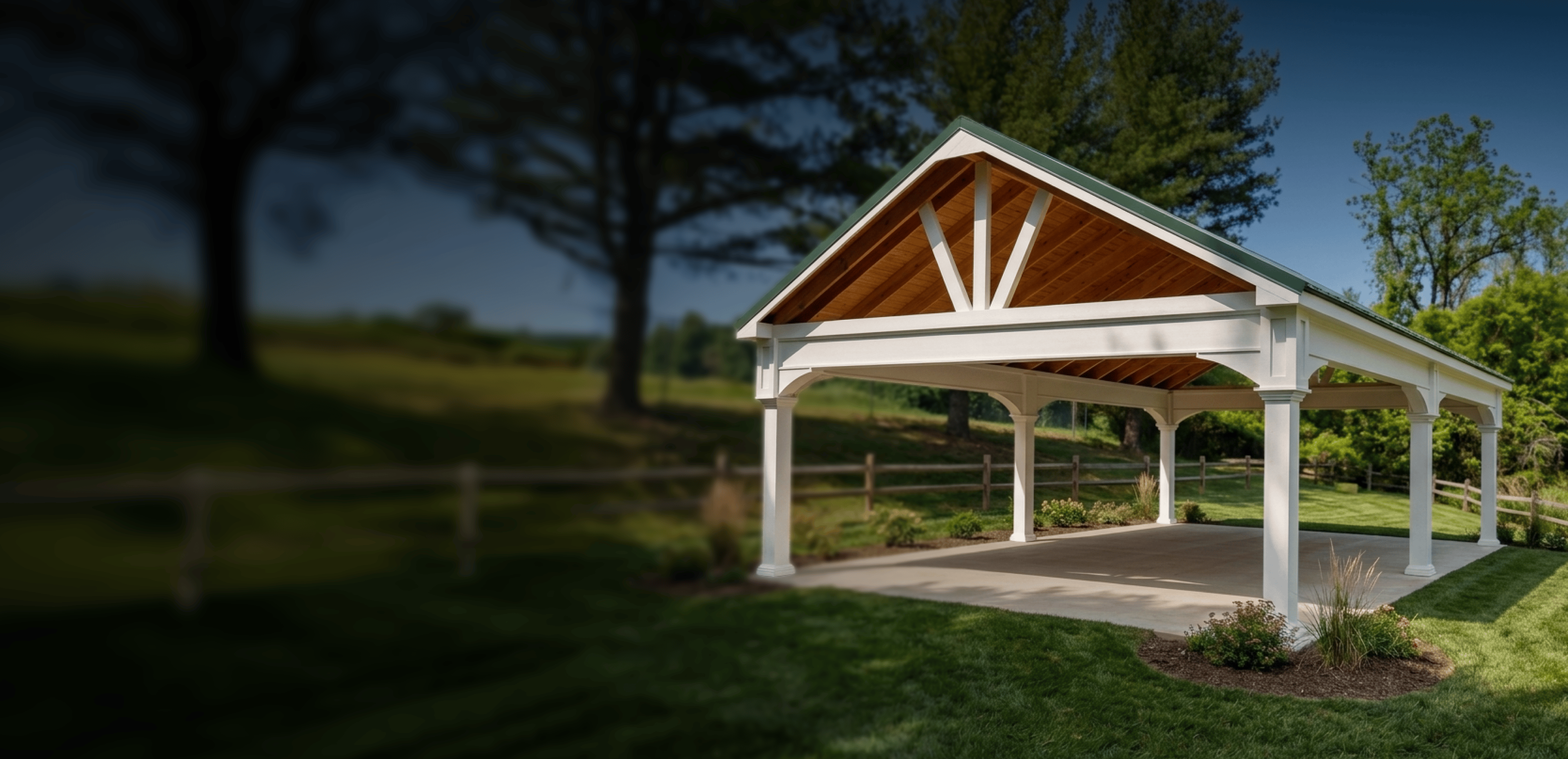 An open-air pavilion with a white frame and a gabled roof set in a grassy yard.