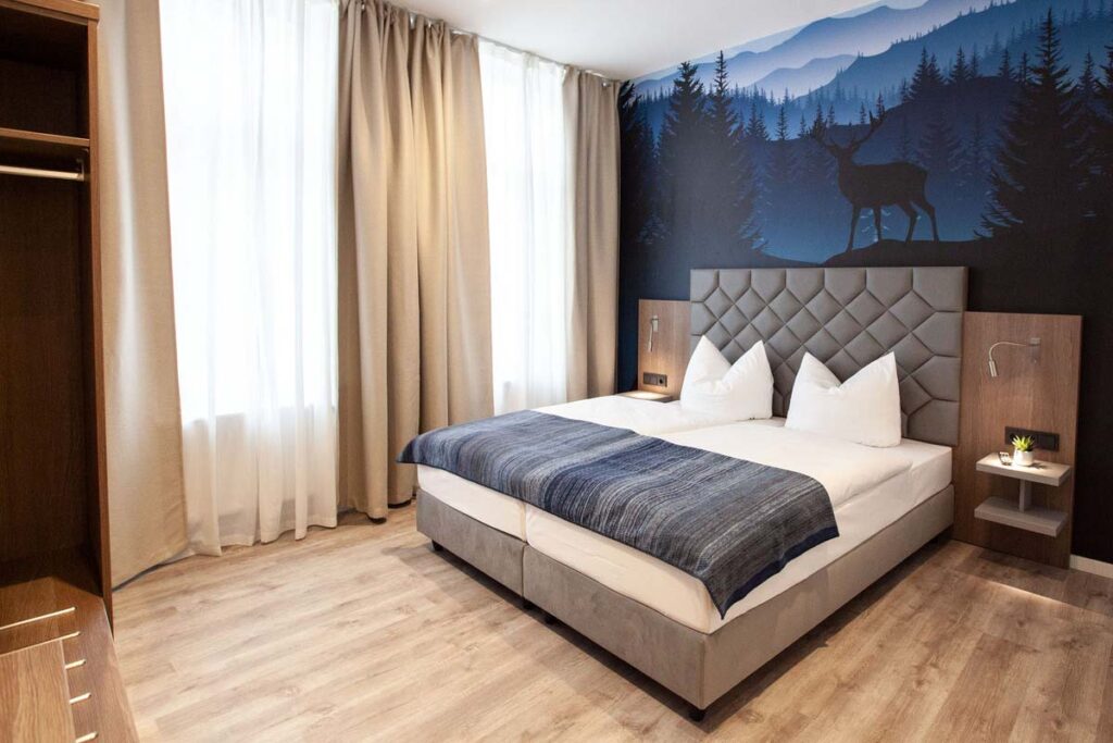 Doppelzimmer mit Doppelbett und hohen Fenstern im LH Hotels Blumenthal