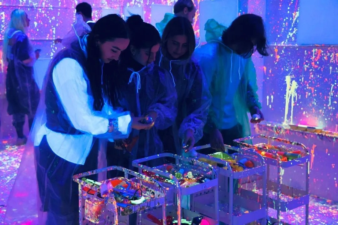 Groupe qui choisit ses peintures fluo dans le labo des couleurs