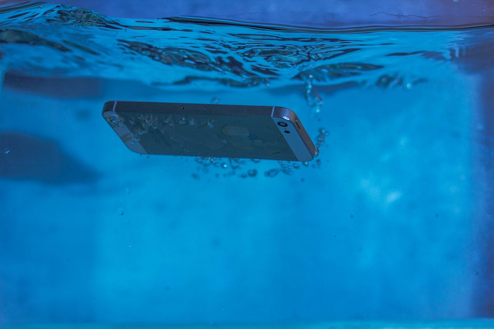 Smartphone onder water met luchtbellen