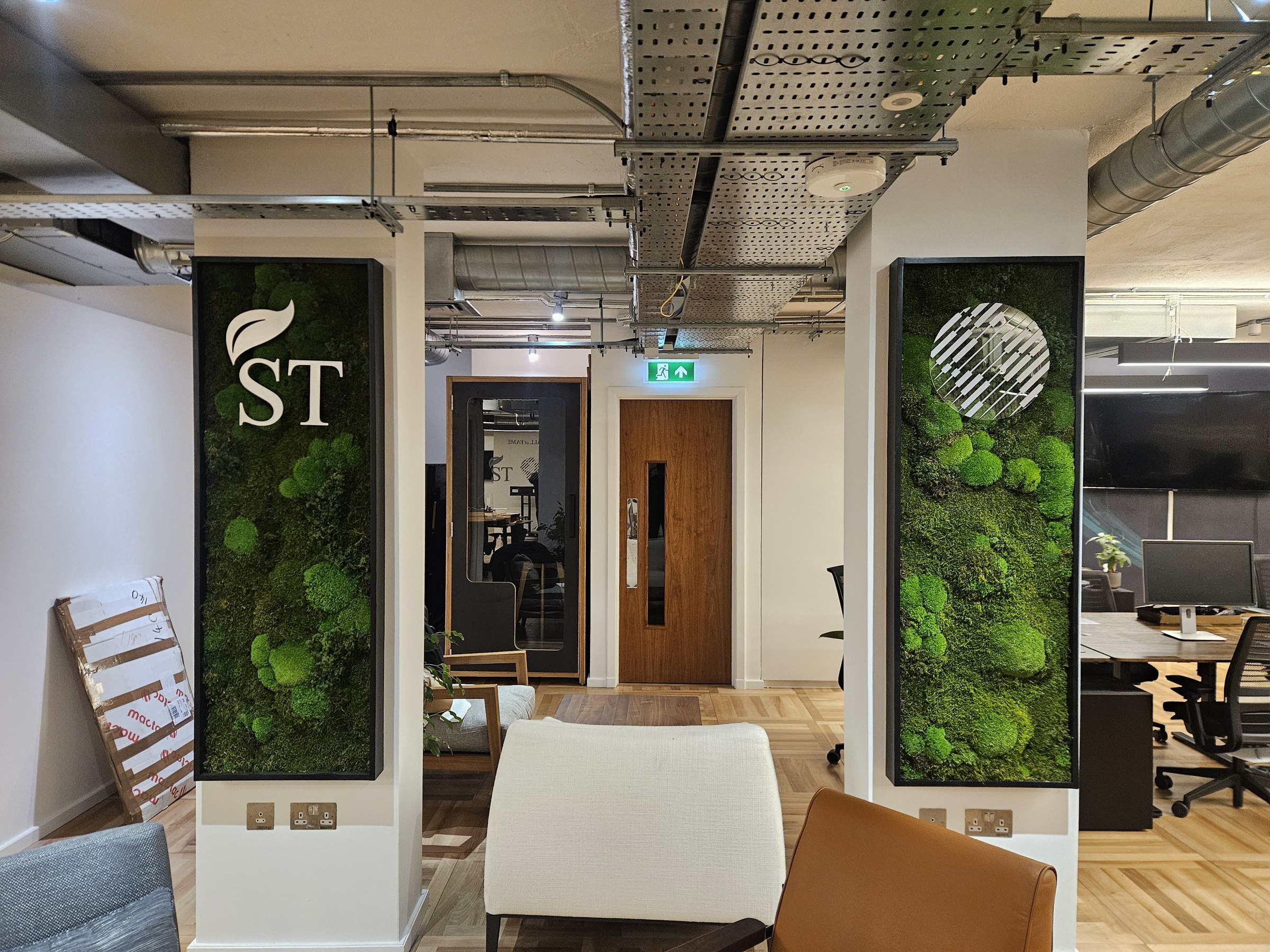 Framed moss installations integrated into columns in a contemporary office.