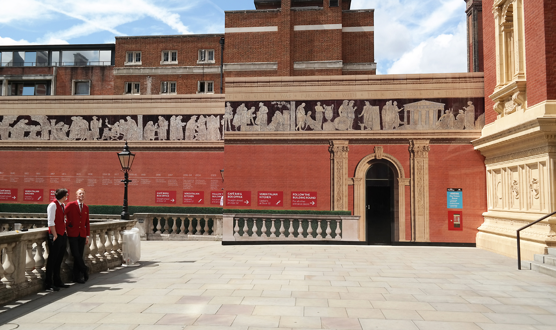 Wide elevation of the Royal Albert Hall architectural construction hoardings and printed heritage frieze.