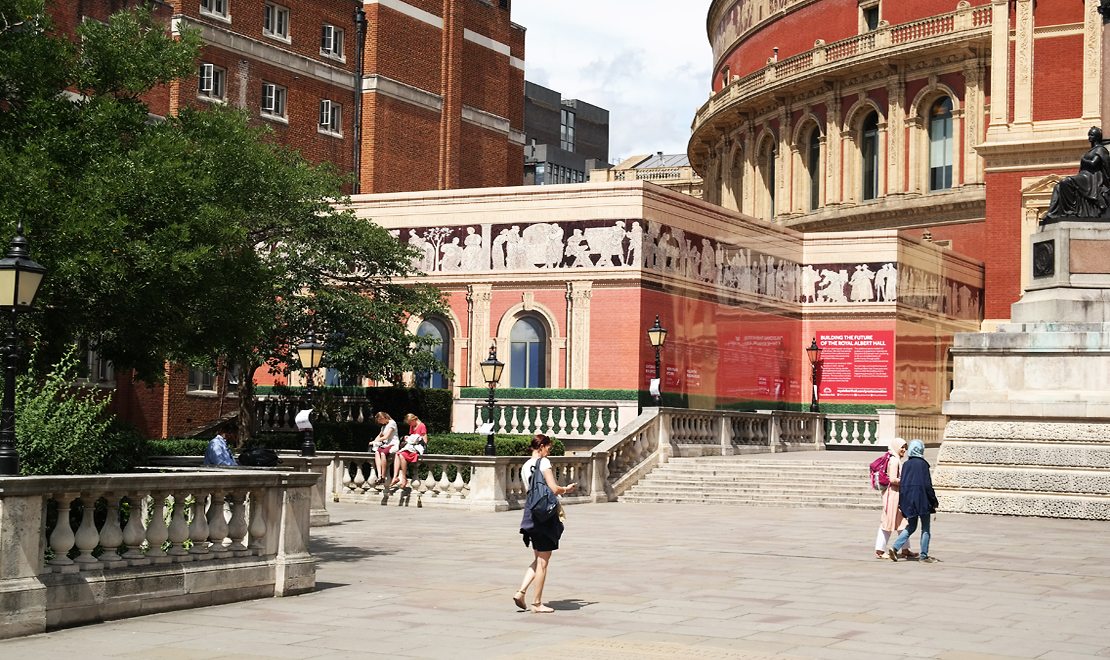 Printed Royal Albert Hall hoarding detail with historic entrance, red directional signs and architectural frieze.