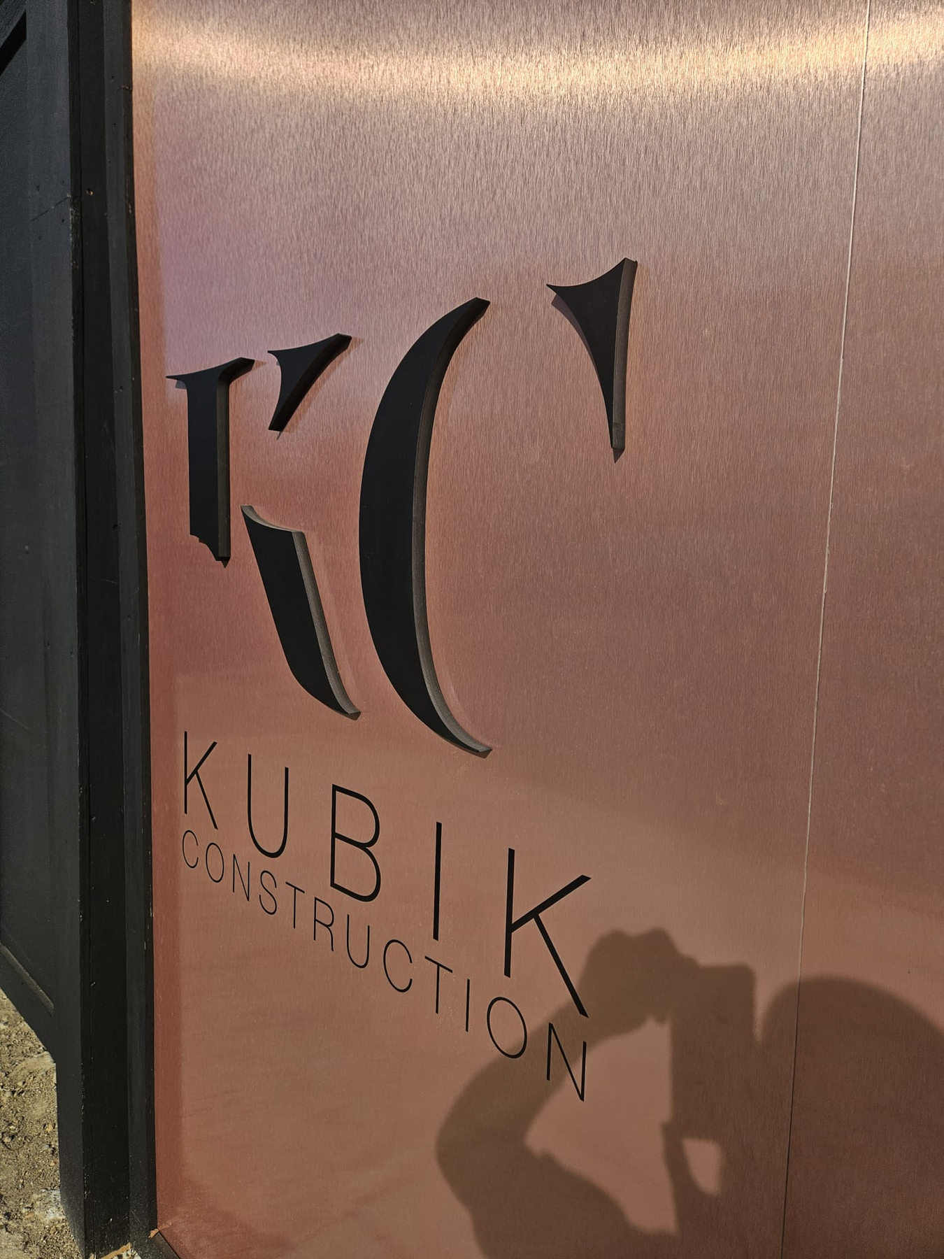 Detailed black dimensional Kubik lettering installed on bronze panels