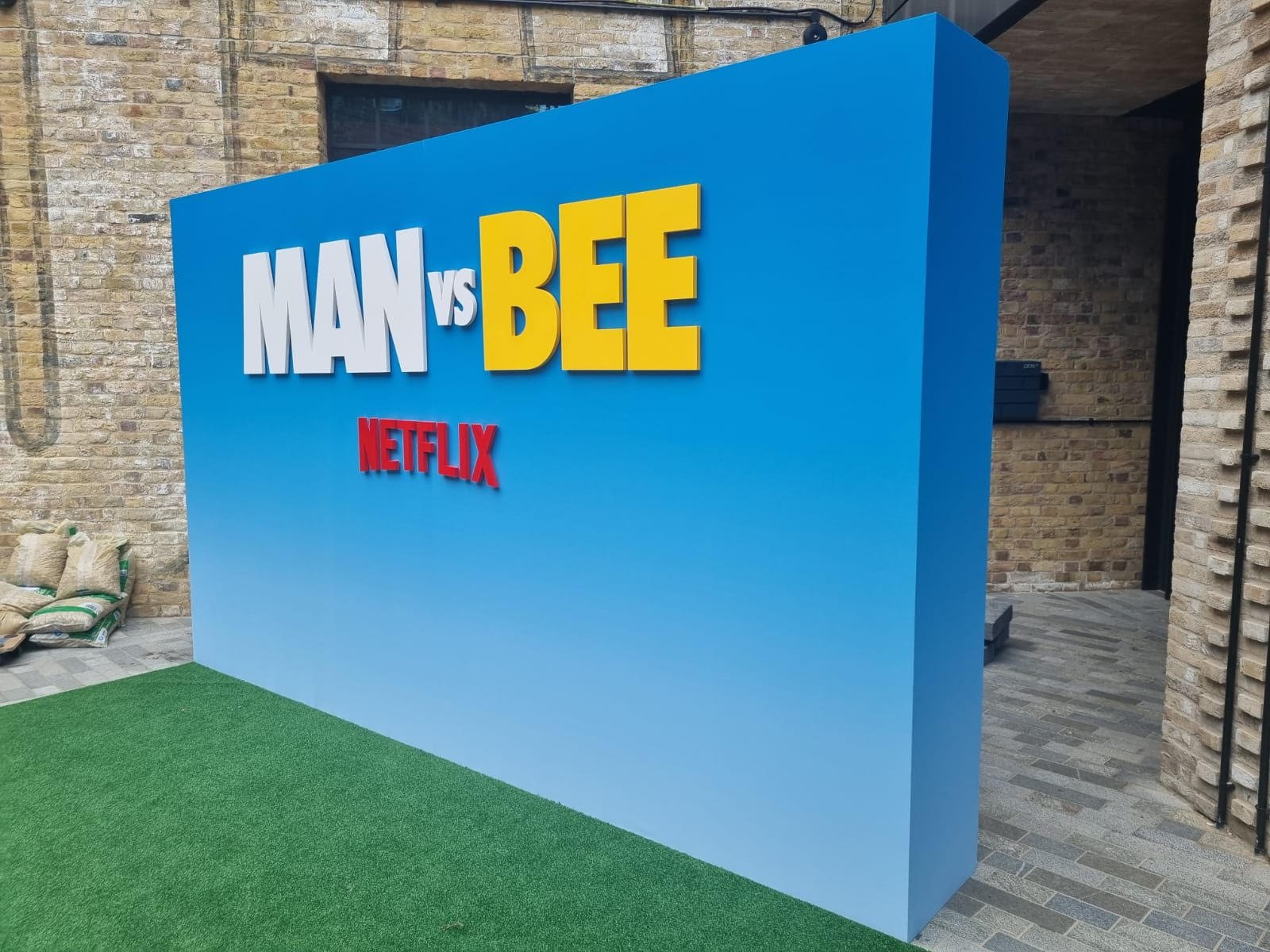 Netflix MAN VS BEE large dimensional lettering on freestanding blue backdrop