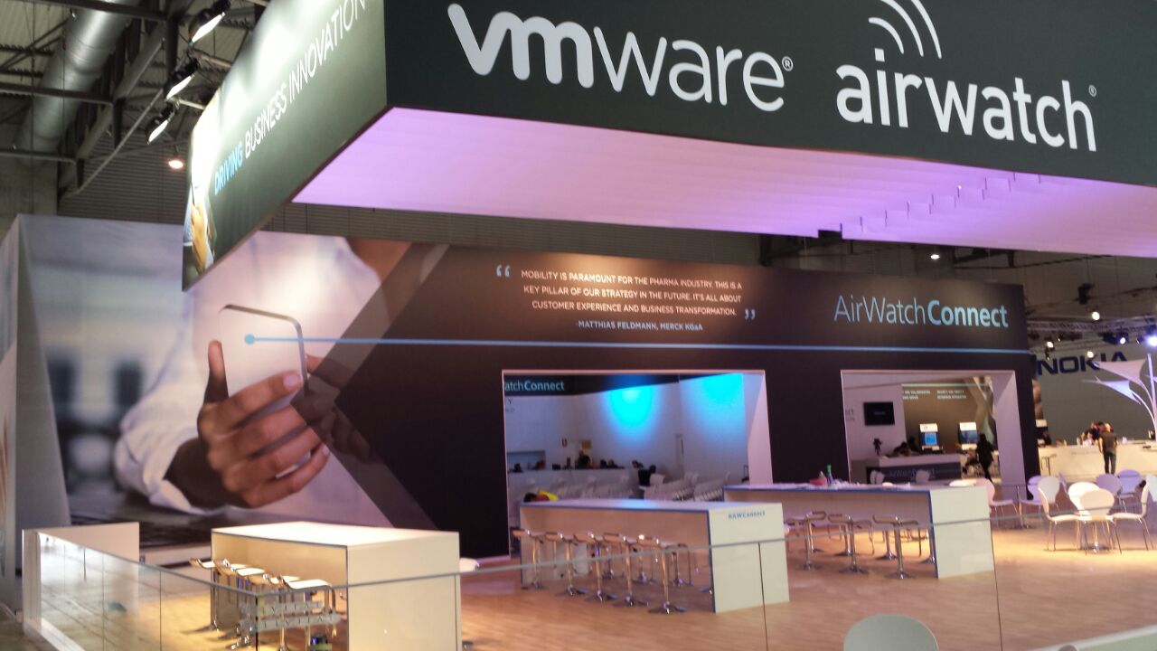 Wide view of the completed VMware AirWatch exhibition stand with suspended fabric branding and meeting areas