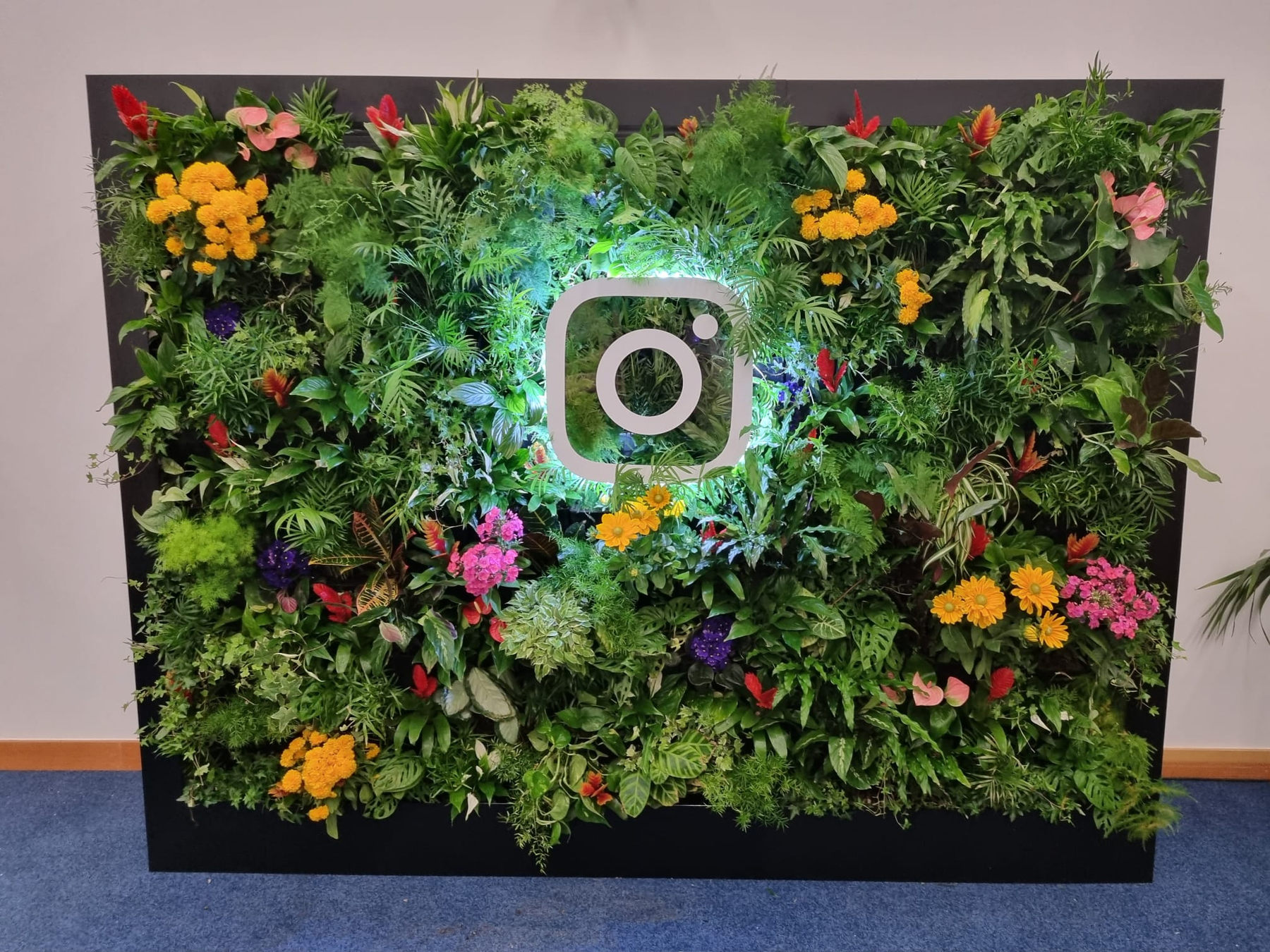 Instagram logo mounted over lush floral event backdrop