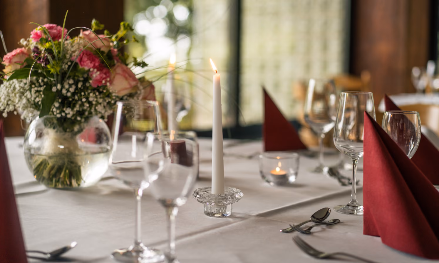 Festliche Tischdekoration mit Blumen und Weingläsern