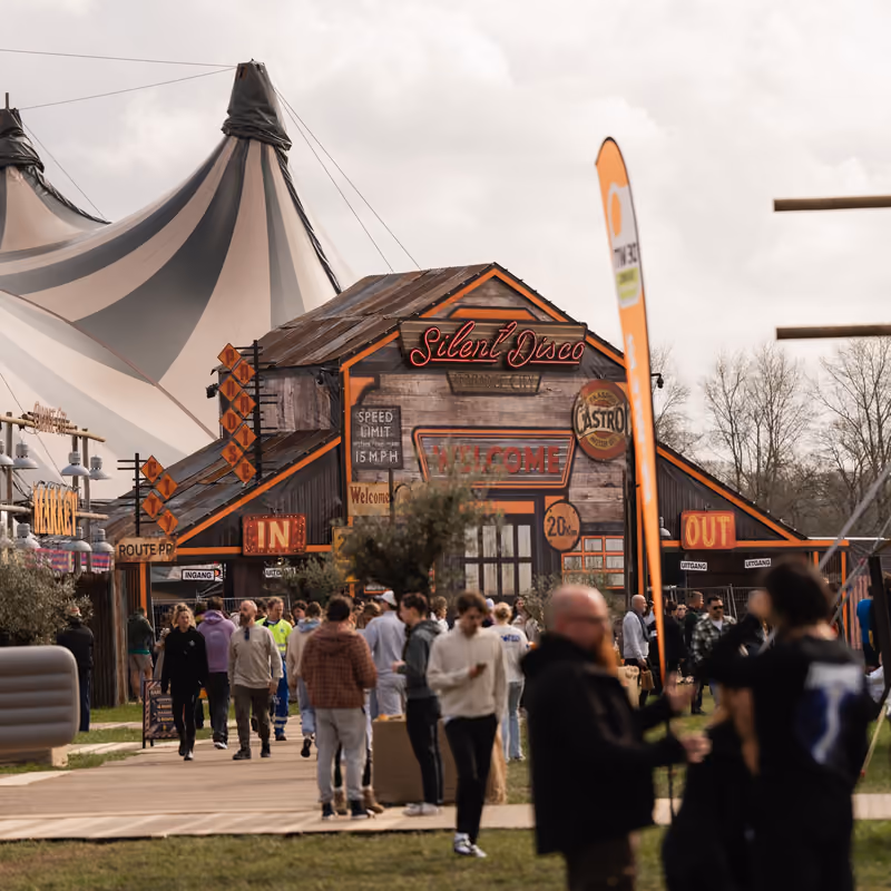 Bezoekers lopen langs de Silent Disco en de circustenten op Paradise City