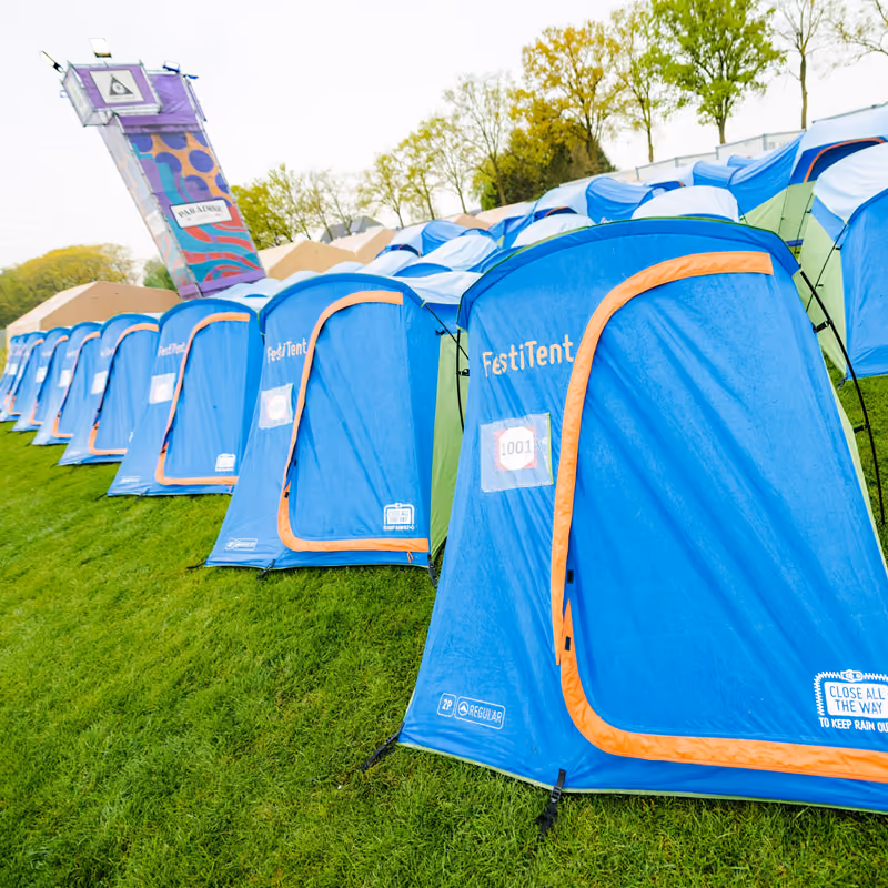 Een rij opgezette blauwe Easycamp-tenten op het gras