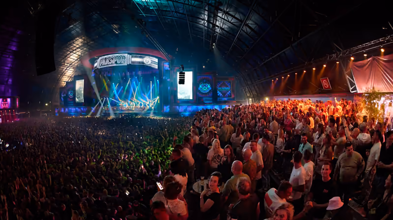 Een volle zaal voor het verlichte Paaspop-podium, van bovenaf gezien